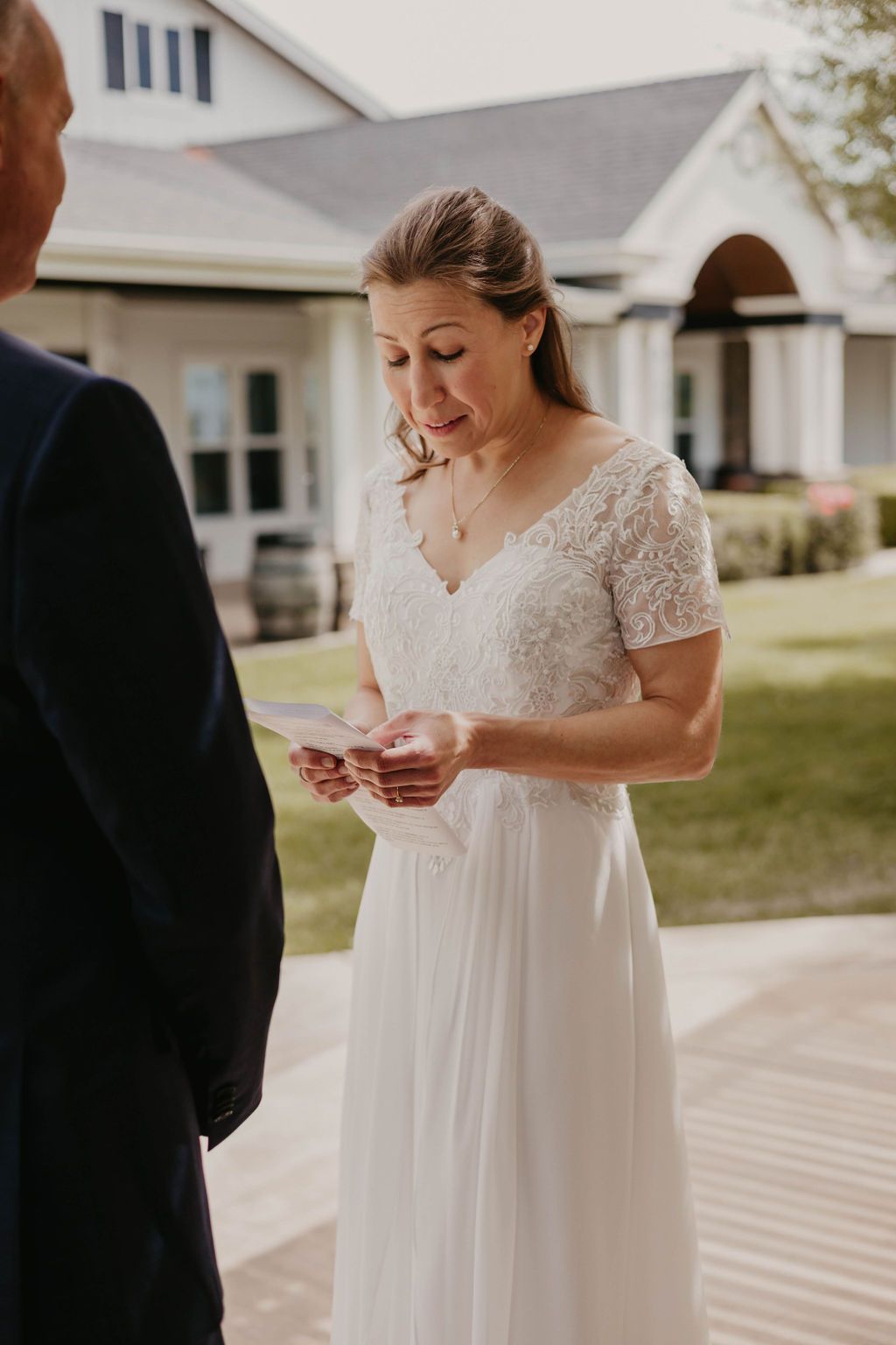 An intimate moment during a wedding ceremony with the bride reading personal vows.