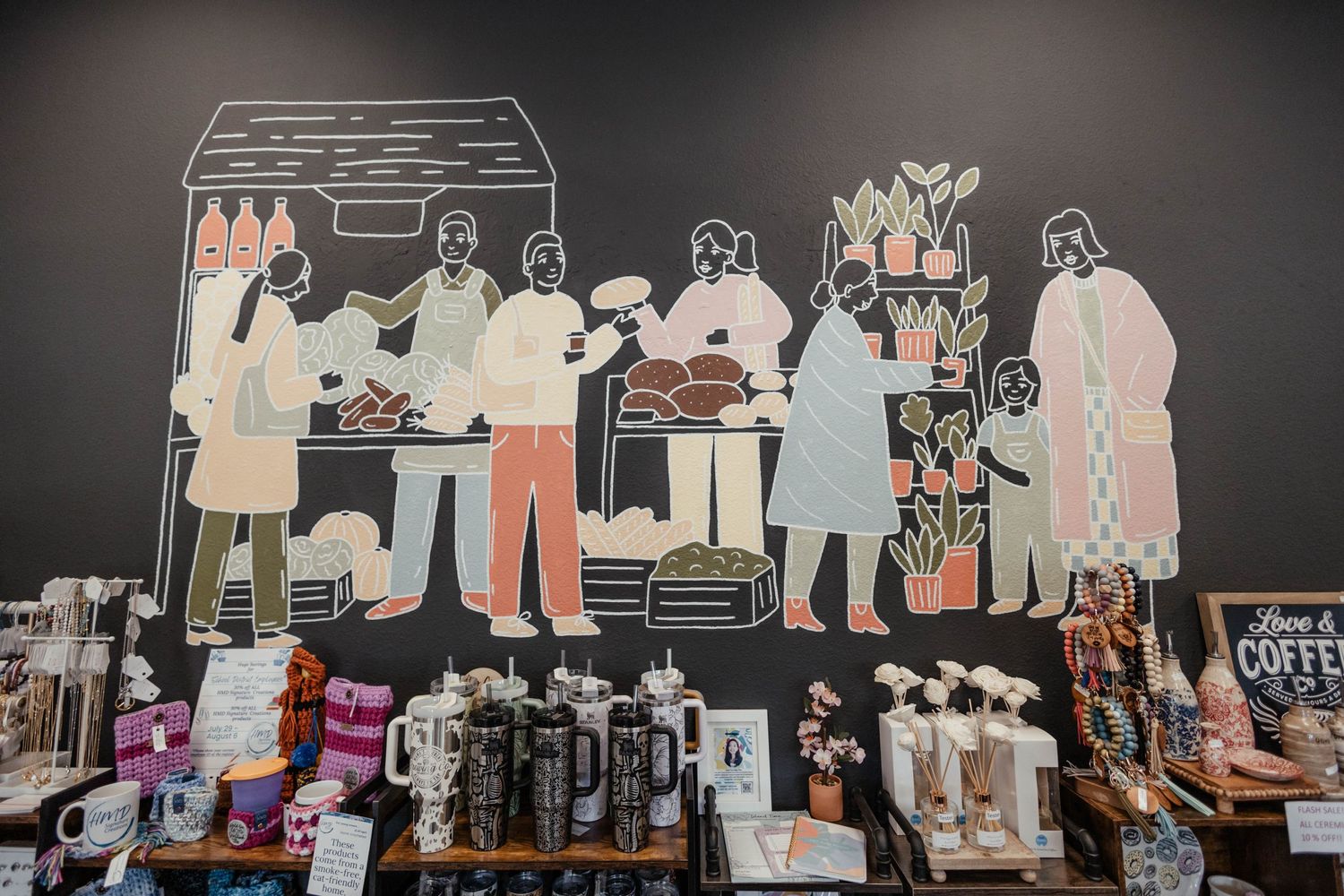 Large decorative wall art showing illustrated figures above product displays in a retail space.