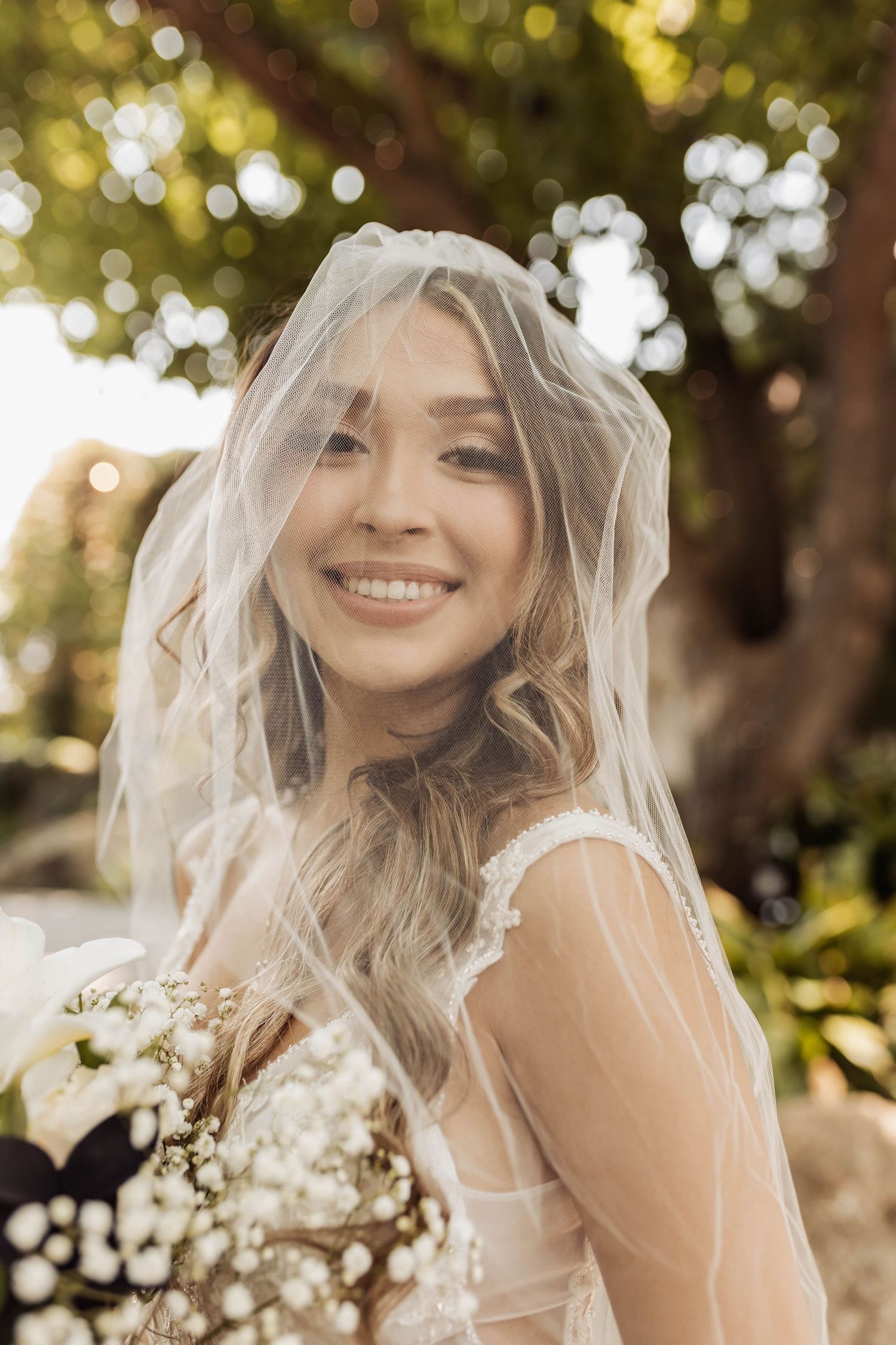 Dreamy bridal veil portraits with soft bokeh lighting and natural garden backdrop.