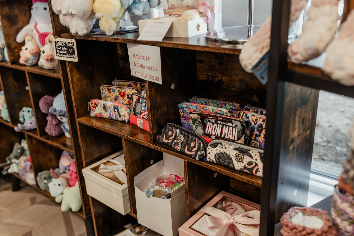Wooden cubby shelving unit filled with plush toys and retail merchandise.