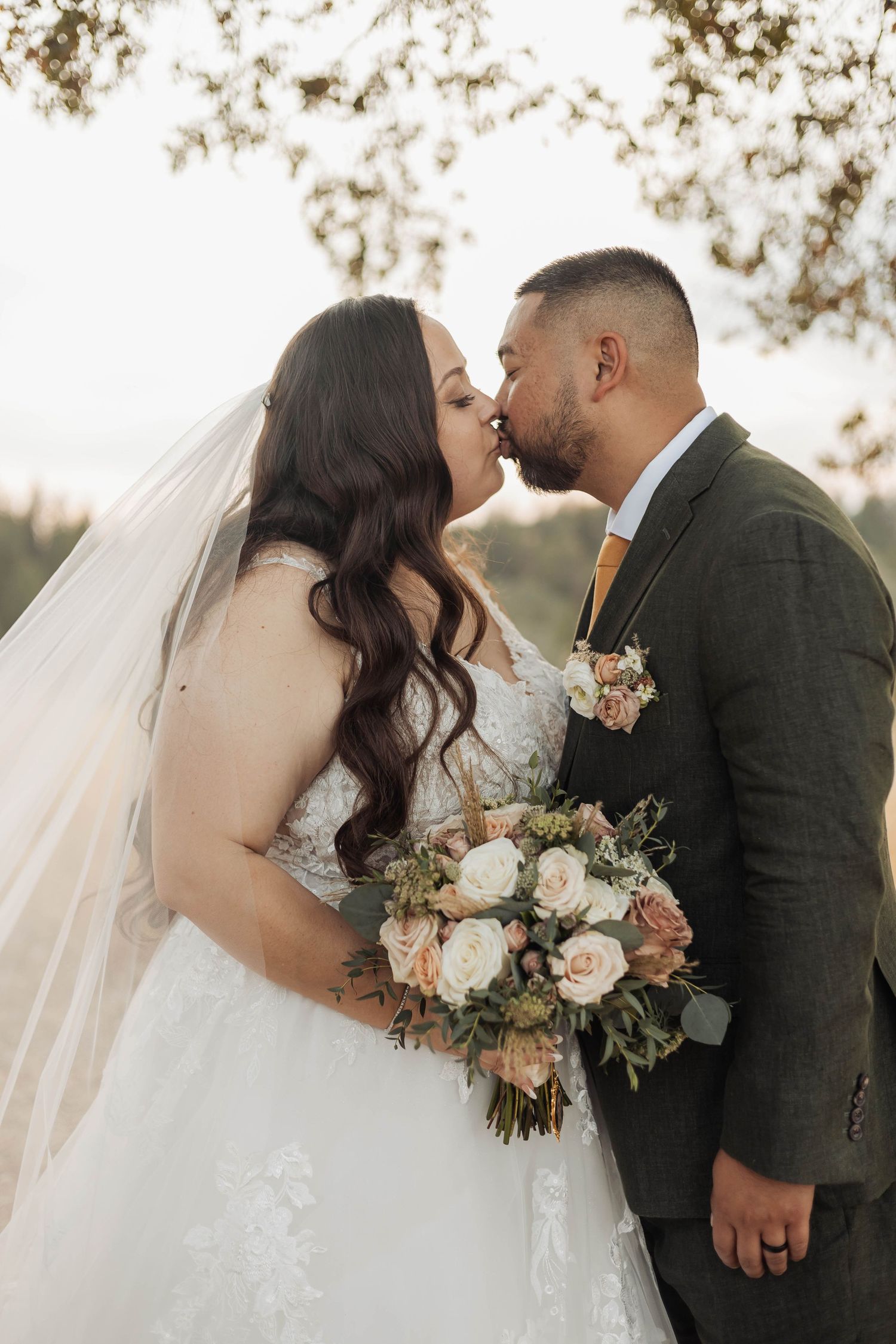 A romantic wedding moment with a beautiful floral bouquet featuring peach and white roses.
