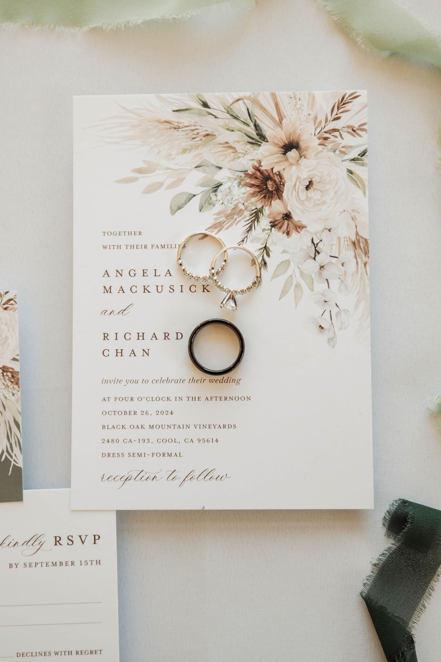 Elegant wedding invitation suite with floral watercolor design and gold wedding rings.