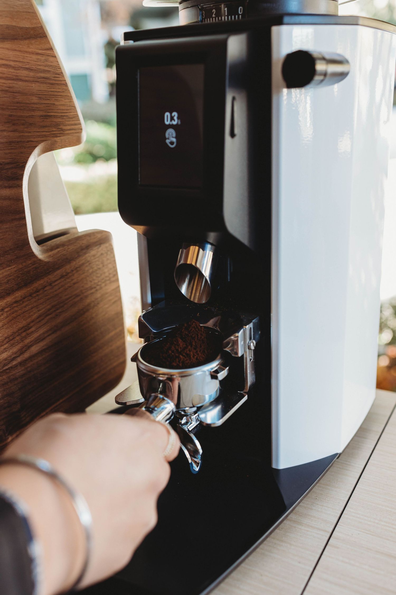 Modern white coffee machine with digital display preparing espresso.