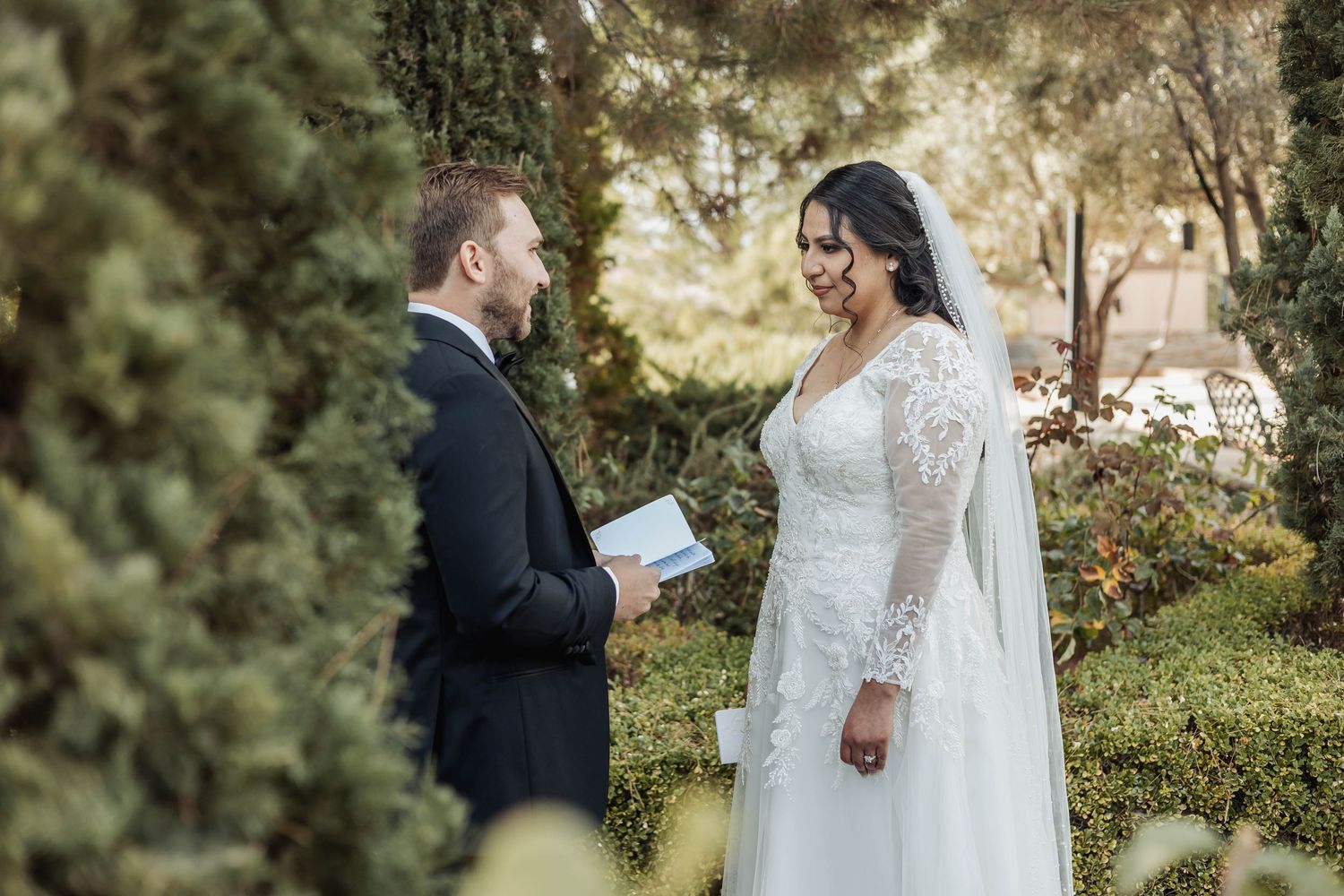 Outdoor wedding ceremony with couple reading personal vows.