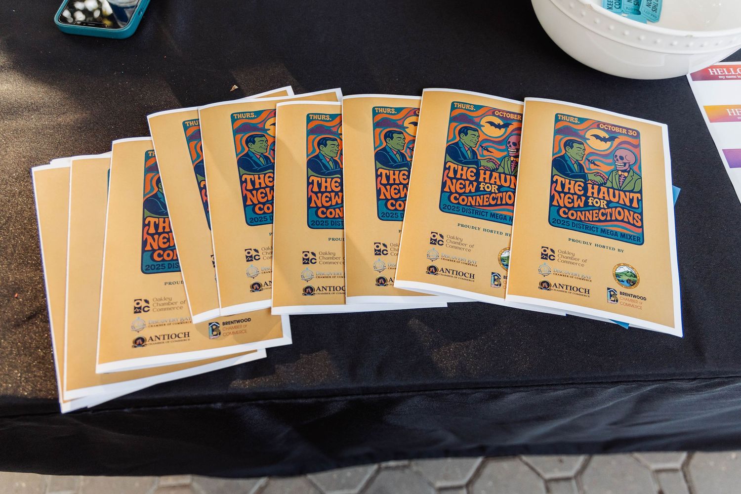 Stack of golden program booklets fanned out on a wooden surface.