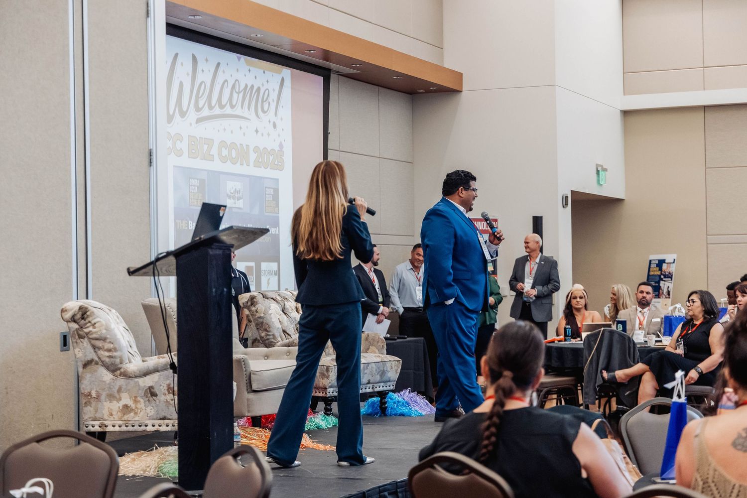 Conference presentation in progress with welcome sign and vintage furniture decor.