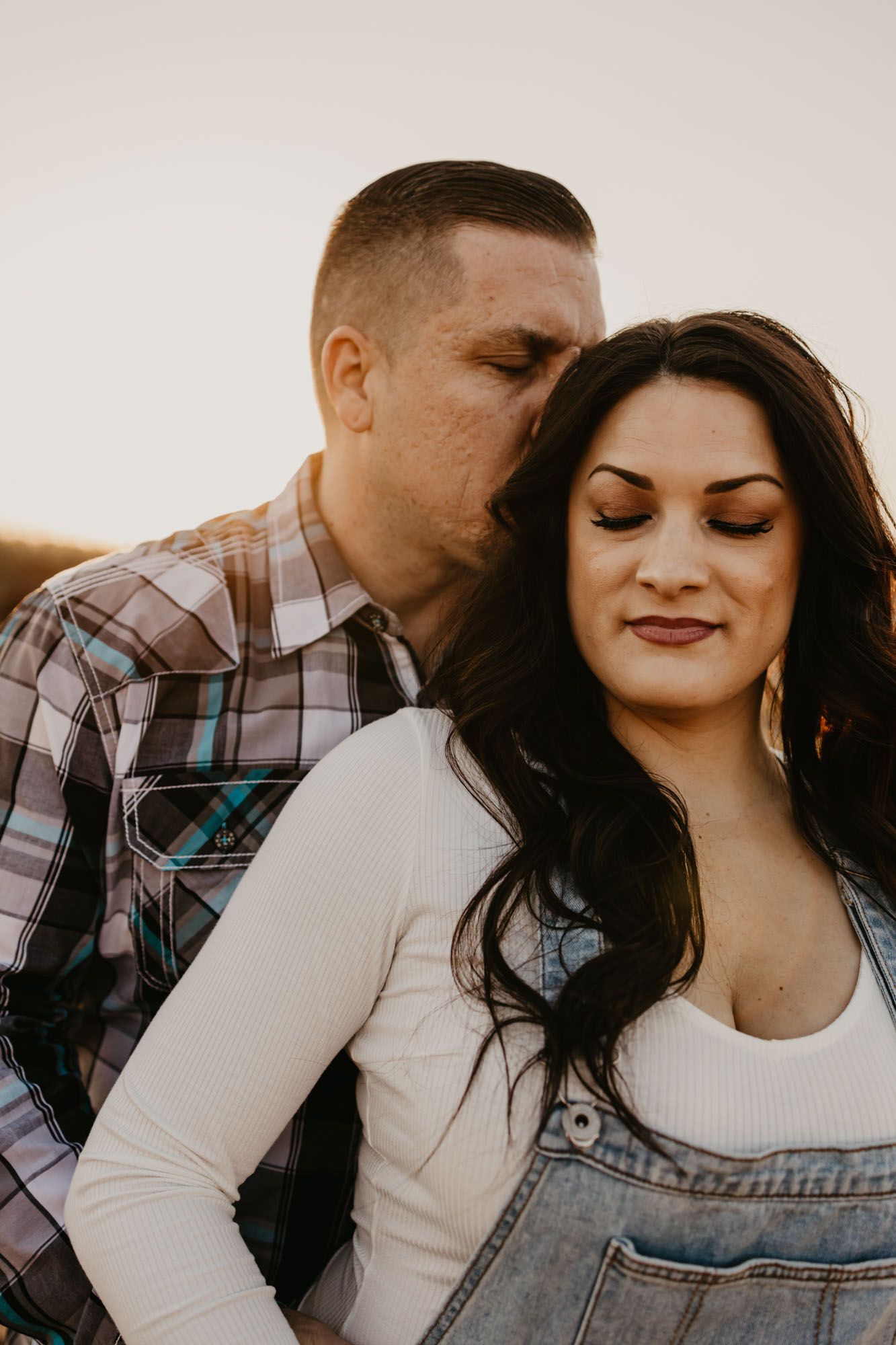 A tender moment between a couple during their sunset engagement photo session.