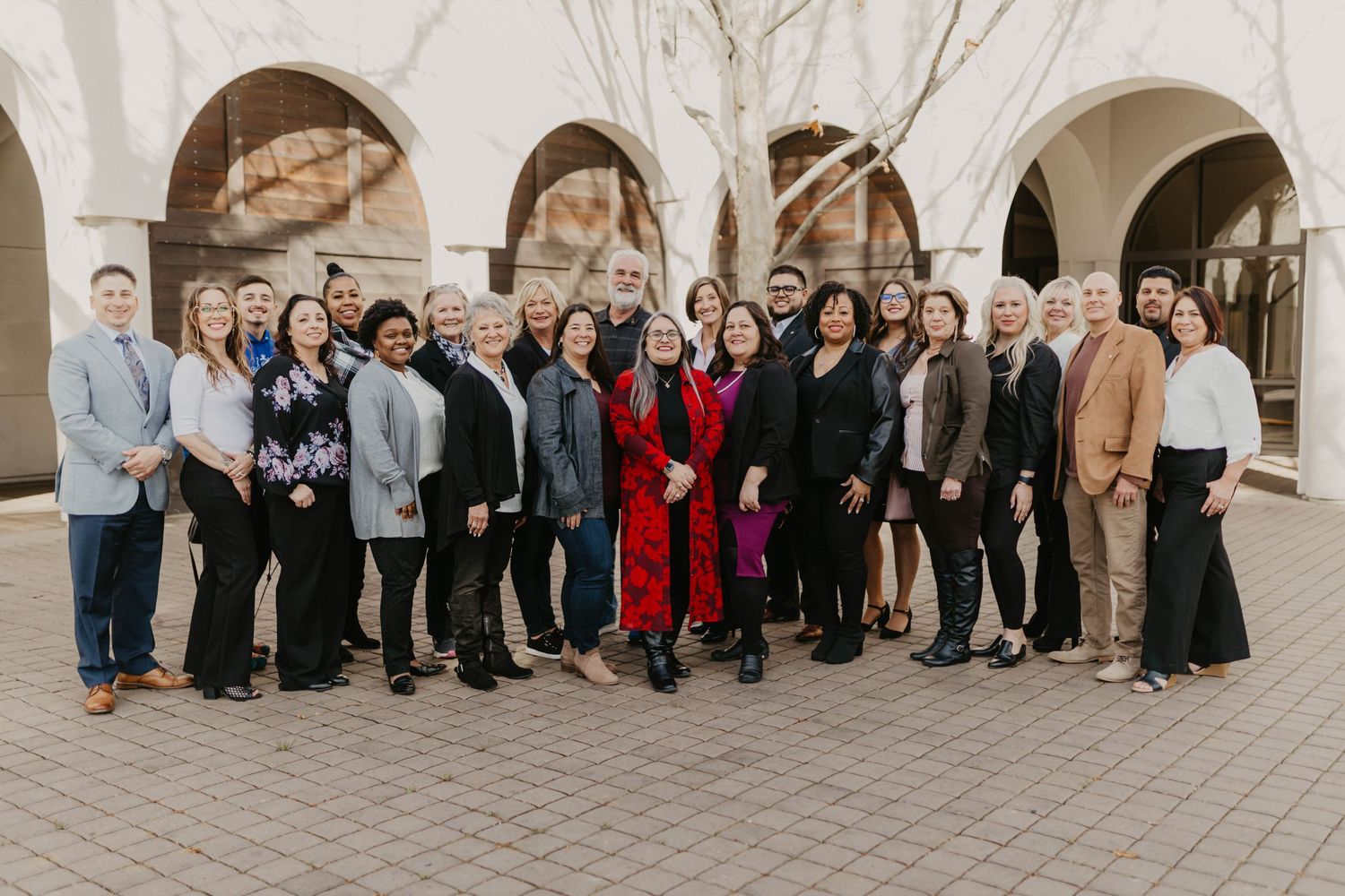 Professional team members gathered for group photo under architectural arches.