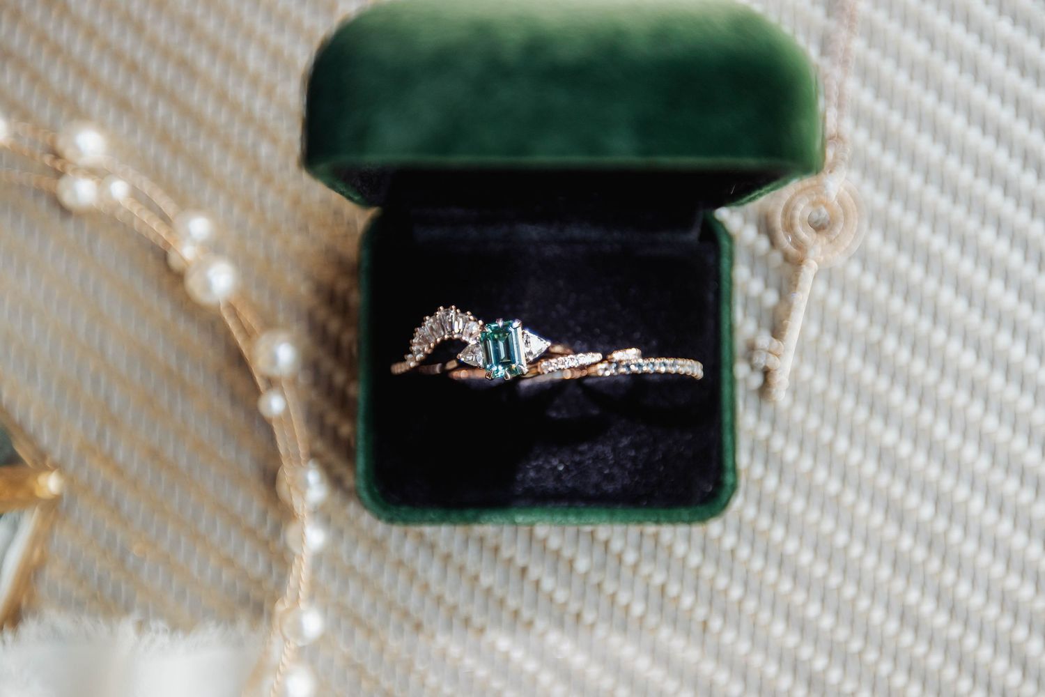 Close-up of engagement ring in an emerald velvet ring box.