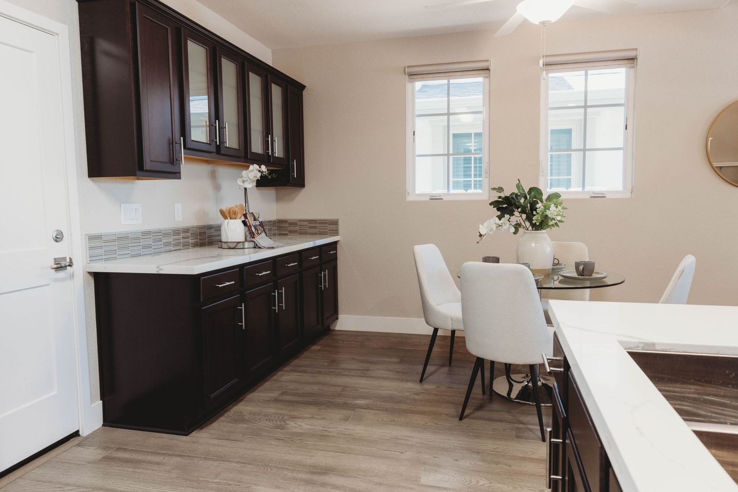 Open floor plan kitchen and dining space with hardwood floors and large windows.