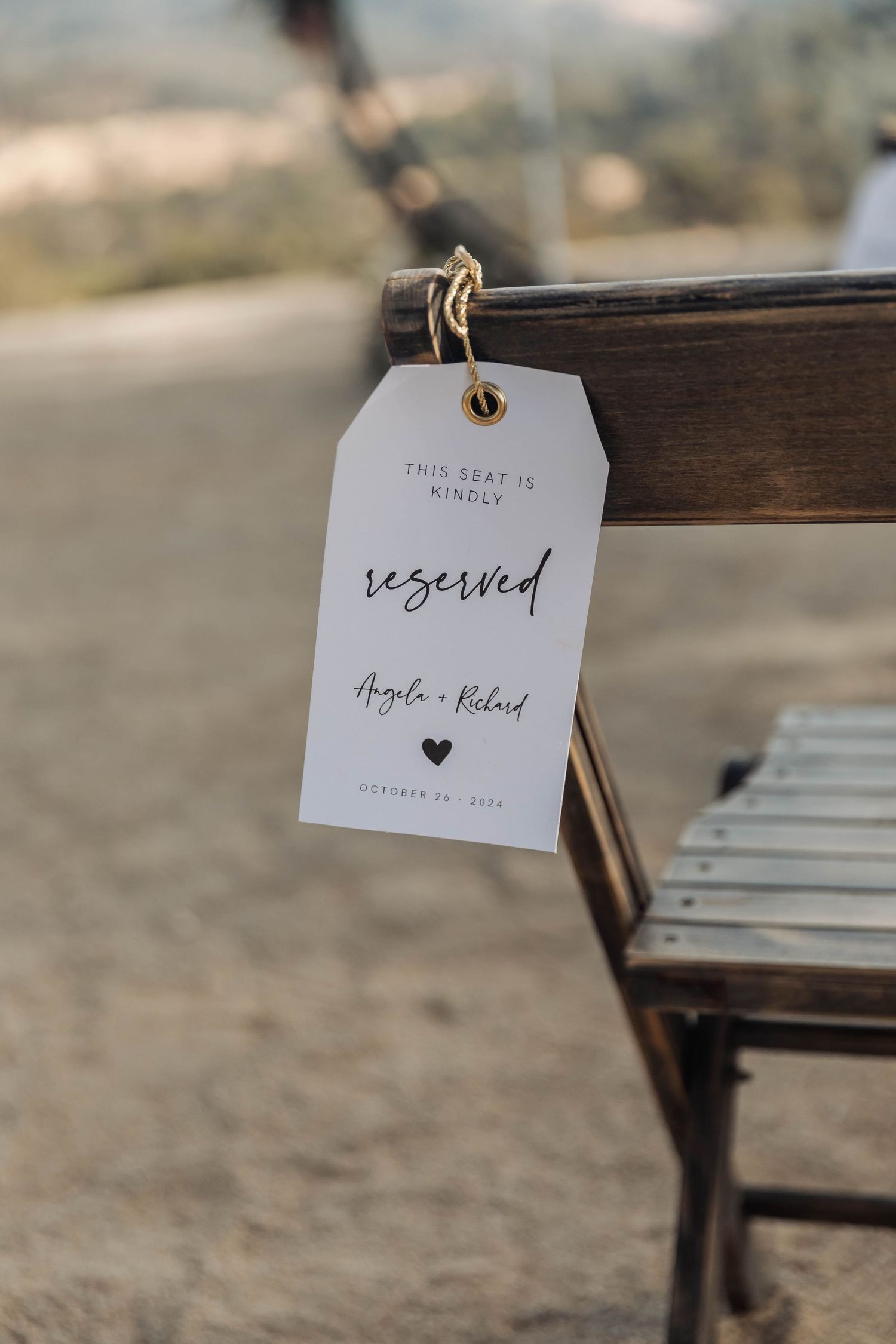 Reserved seating tag for wedding ceremony hanging on wooden chair.