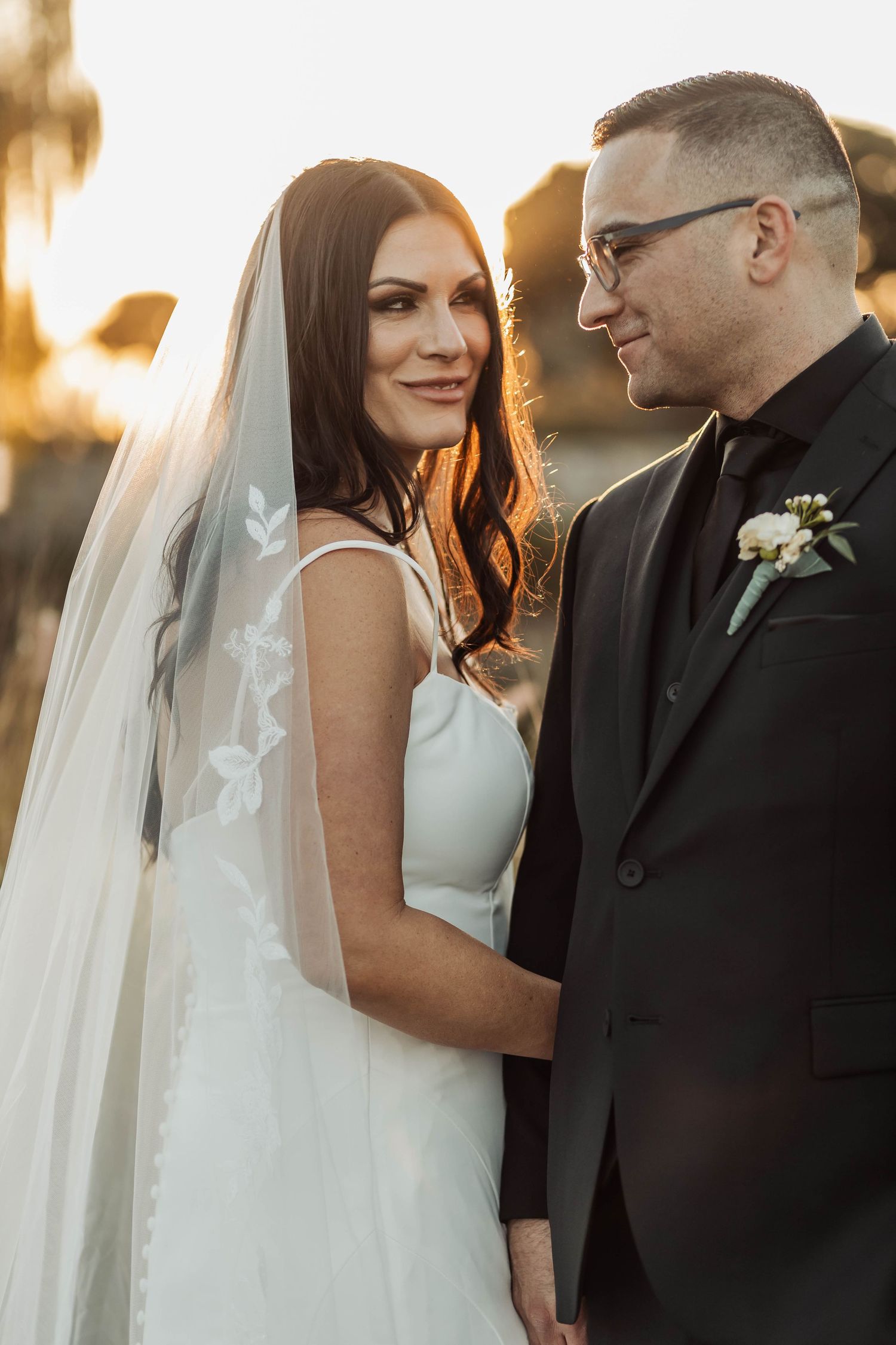 Romantic sunset portraits of newlyweds in elegant wedding attire.