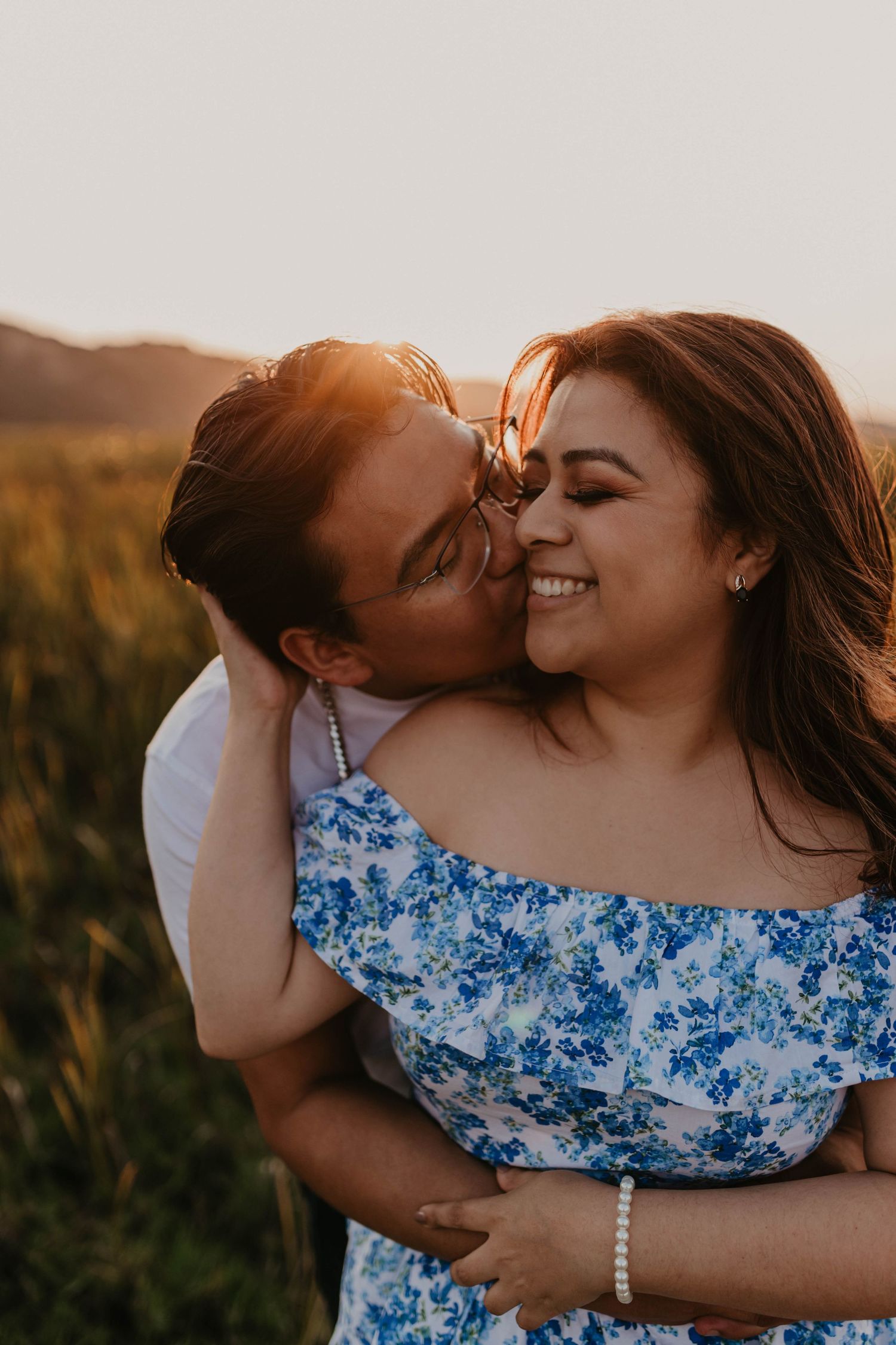 An intimate outdoor photoshoot showing a couple sharing a loving embrace in nature.