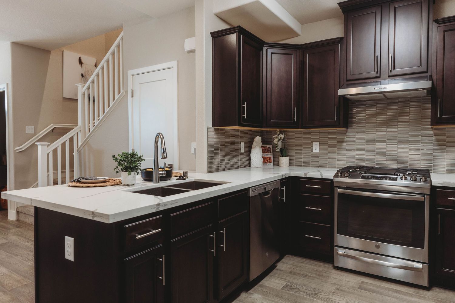 Spacious kitchen featuring dark espresso cabinets, stainless appliances, and light countertops.