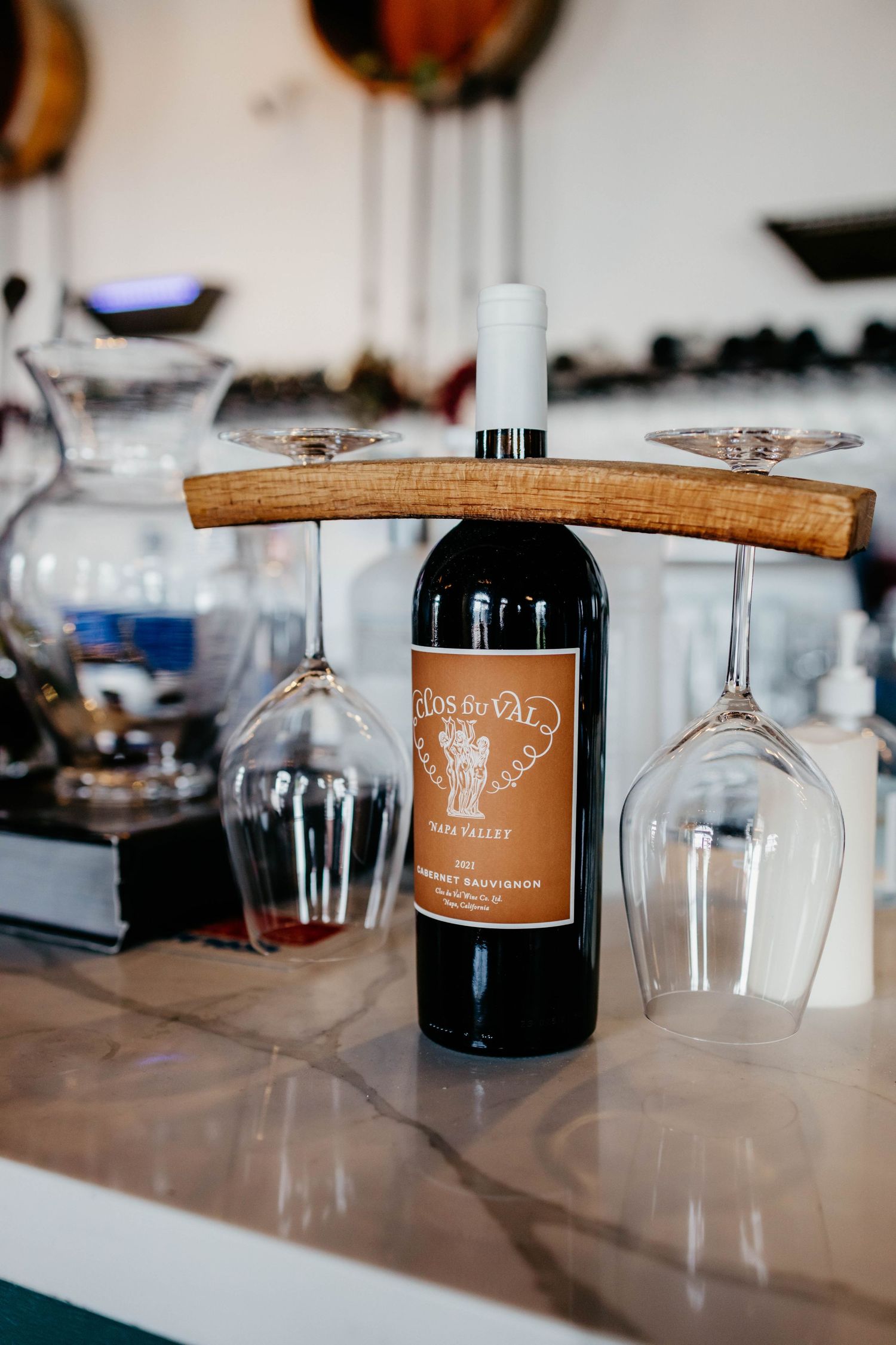 Wine glasses displayed upside down on wooden holders with Dale Vino branding.