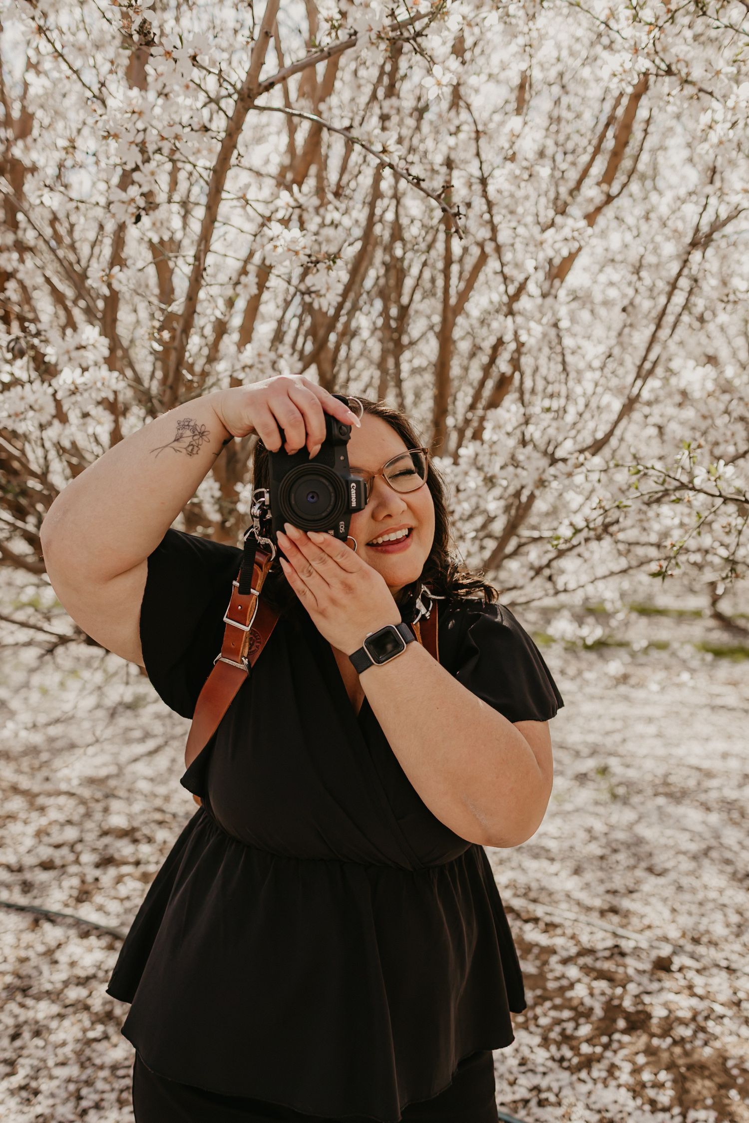 Photographer taking pictures among blooming spring cherry blossom trees.