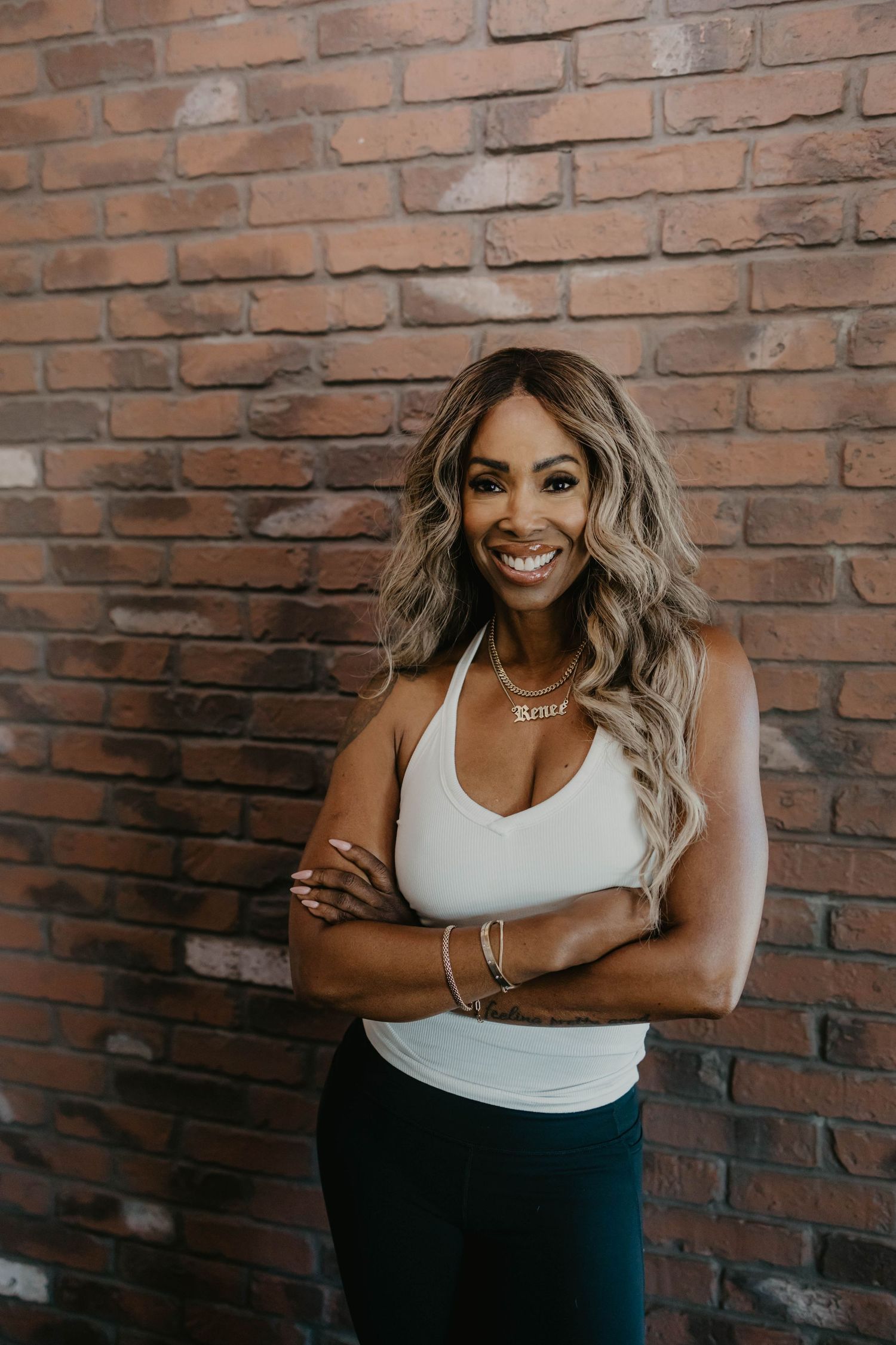 Lifestyle portraits with joyful expressions against rustic brick background.