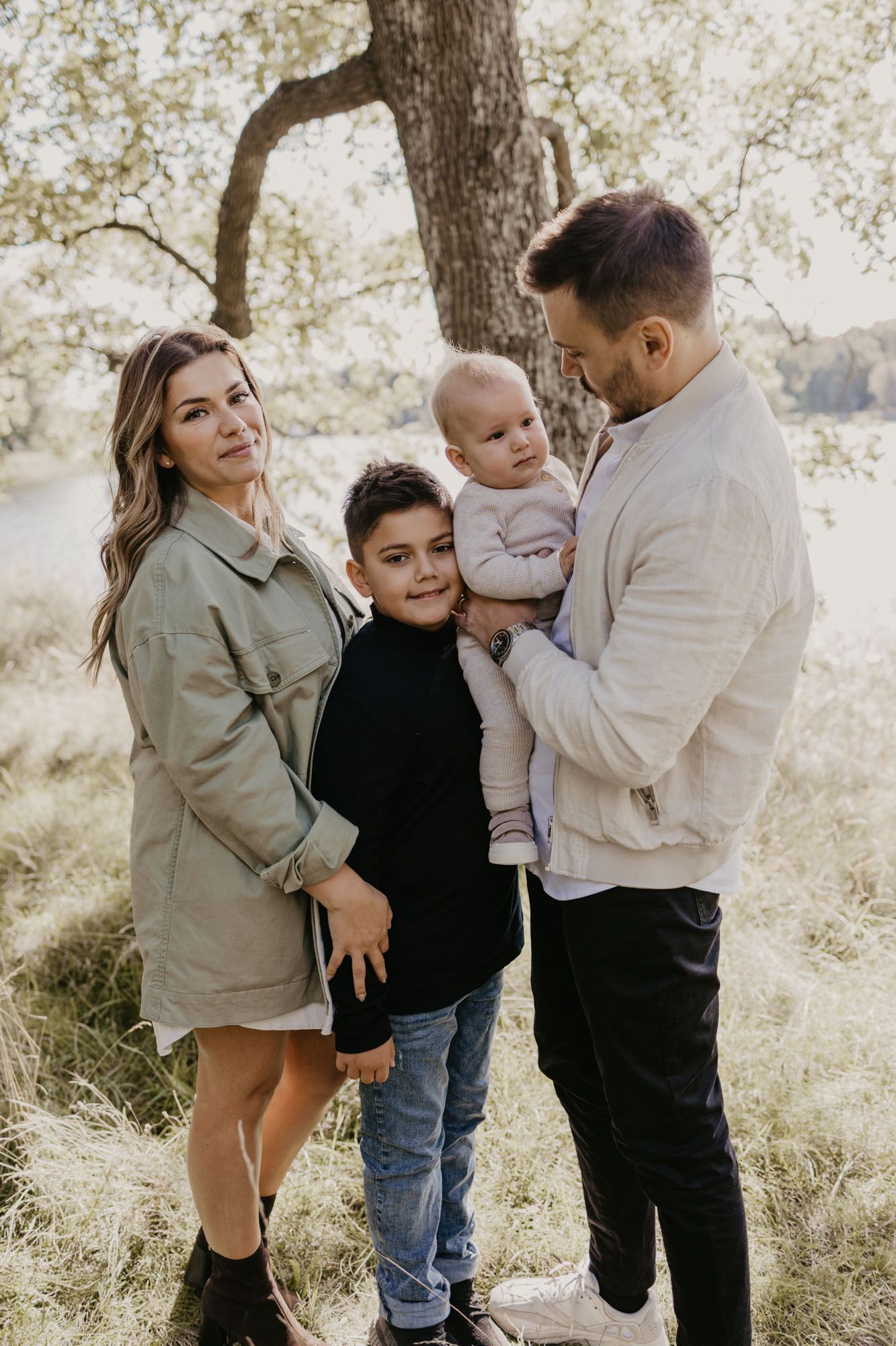 Beautiful outdoor family portrait with natural lighting and oak trees in background.