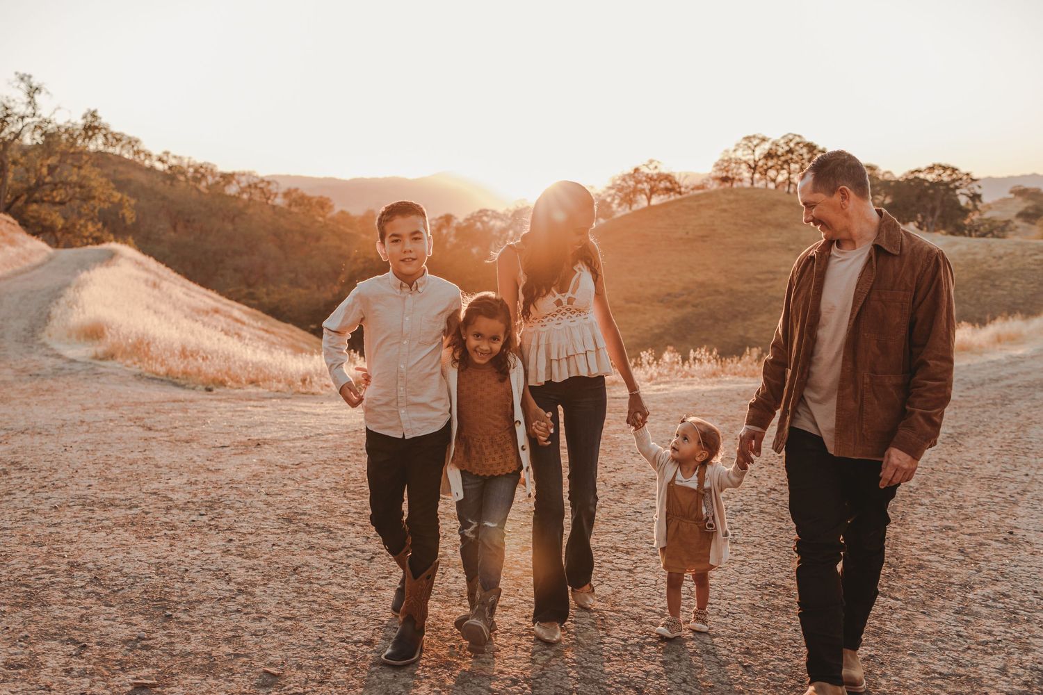 Group enjoying a sunset stroll on a hillside trail in warm evening light.
