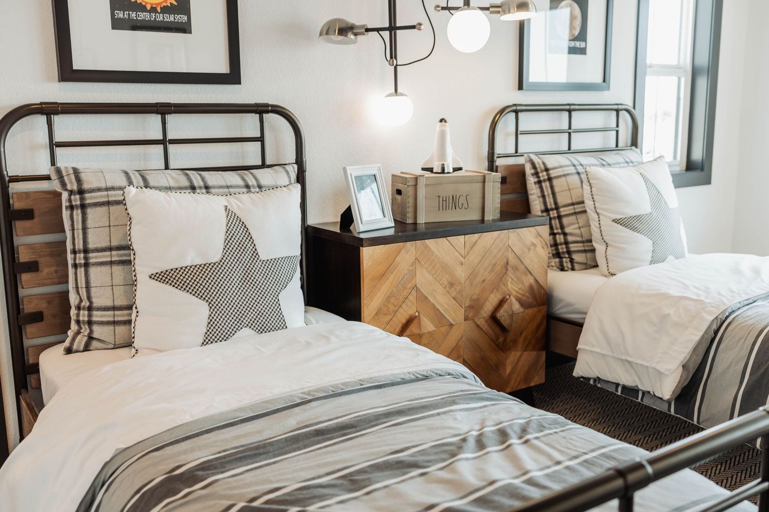 Cozy bedroom with plaid pillows and textured bedding in neutral tones creating a welcoming atmosphere.