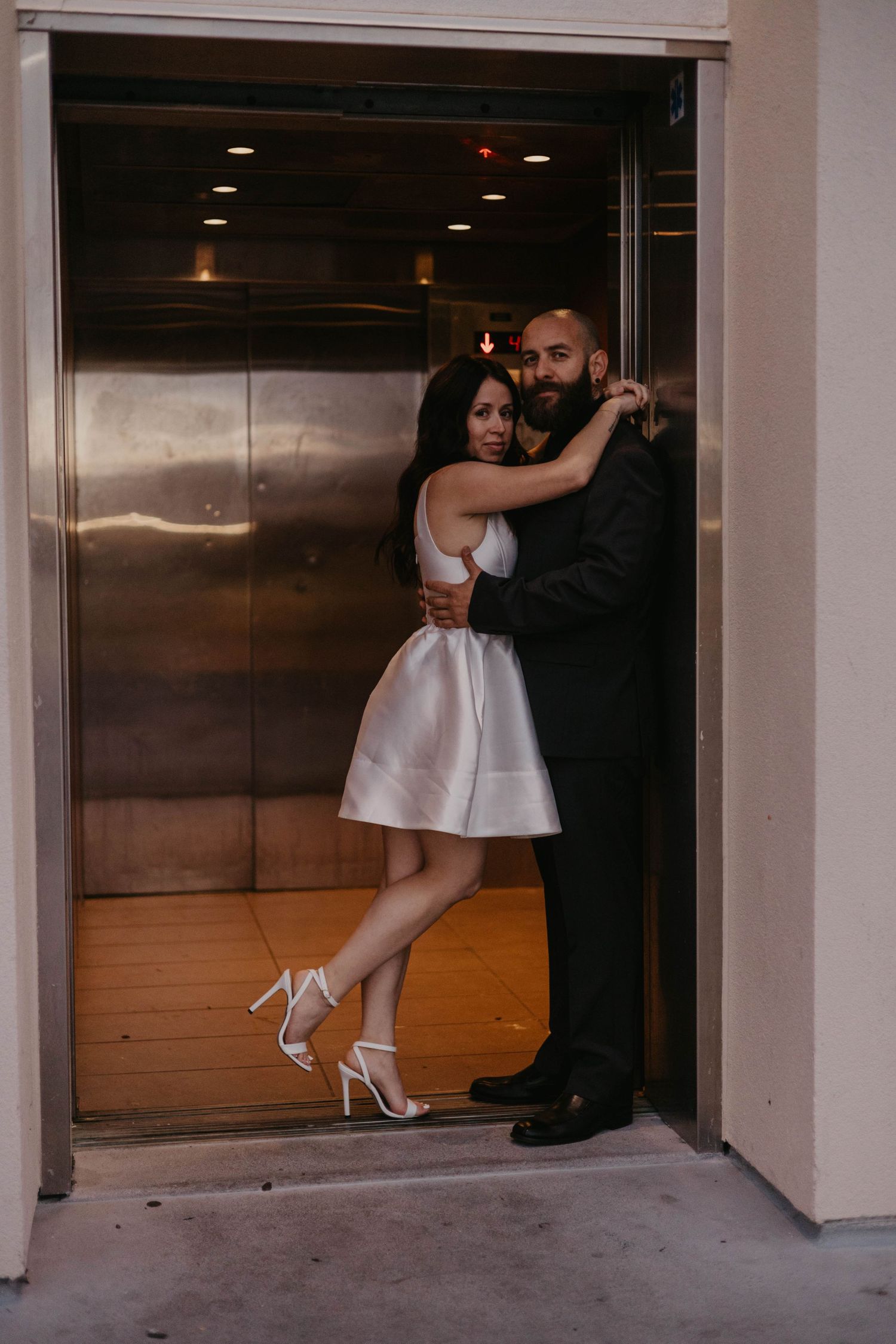 Couple shares romantic dance moment in elevator doorway.