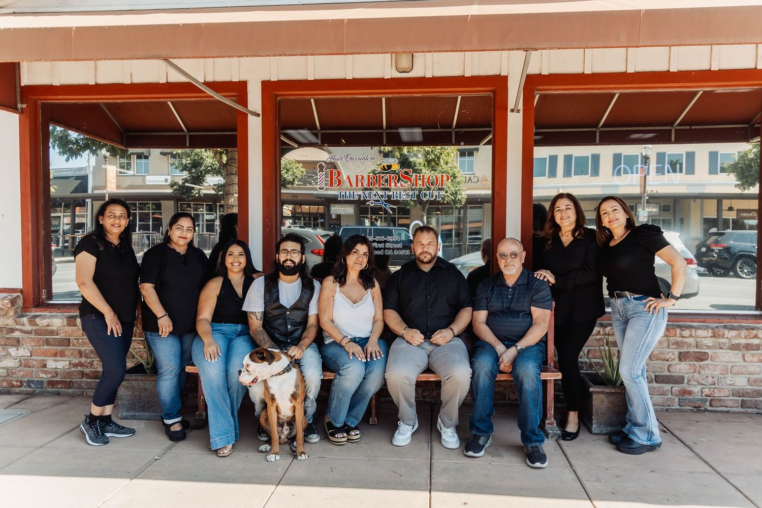 Group photo of team members sitting on steps outside building.