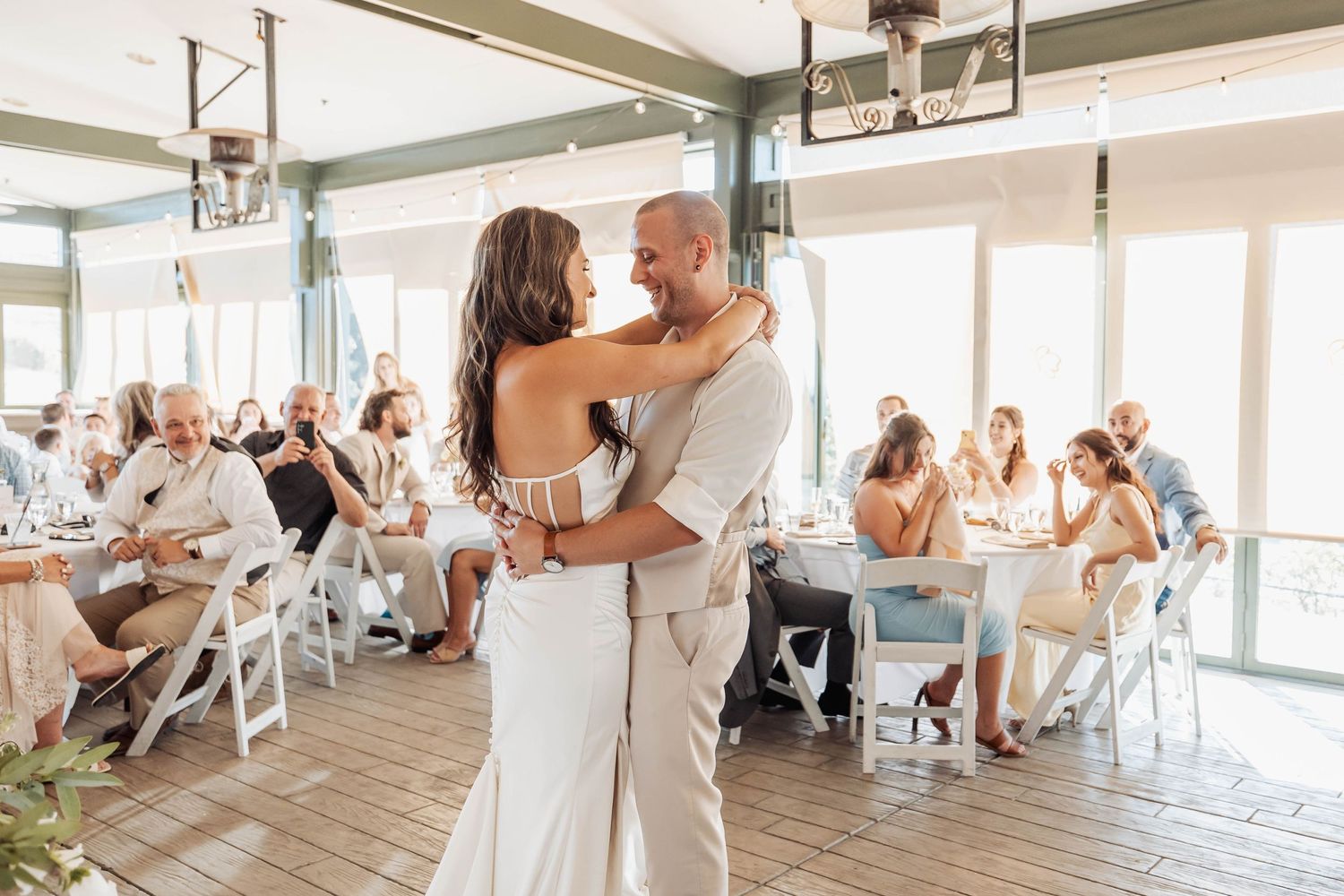 Couples share their first dance at a bright, airy wedding reception venue.