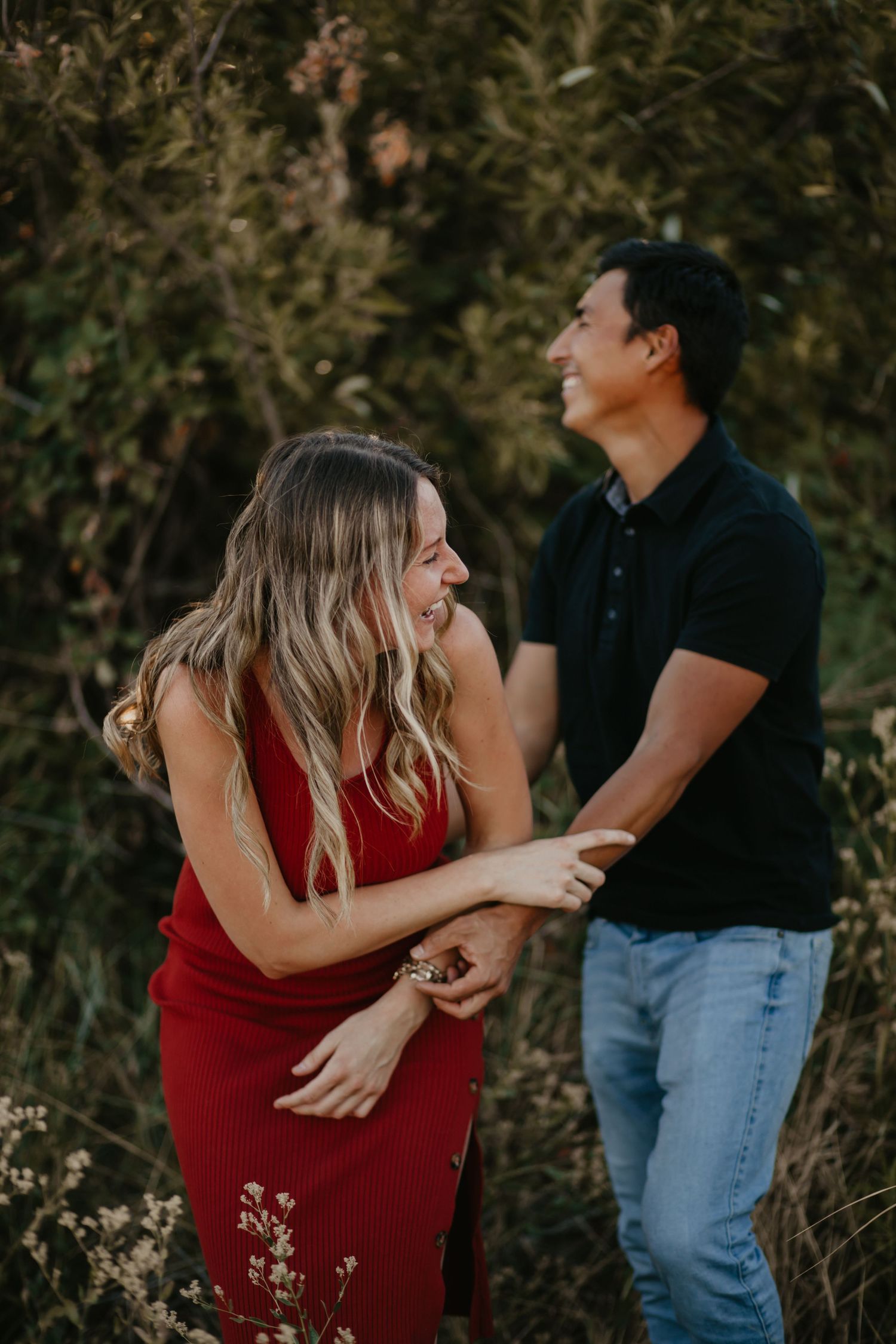 A playful couple shares joyful moments during their outdoor photo session.