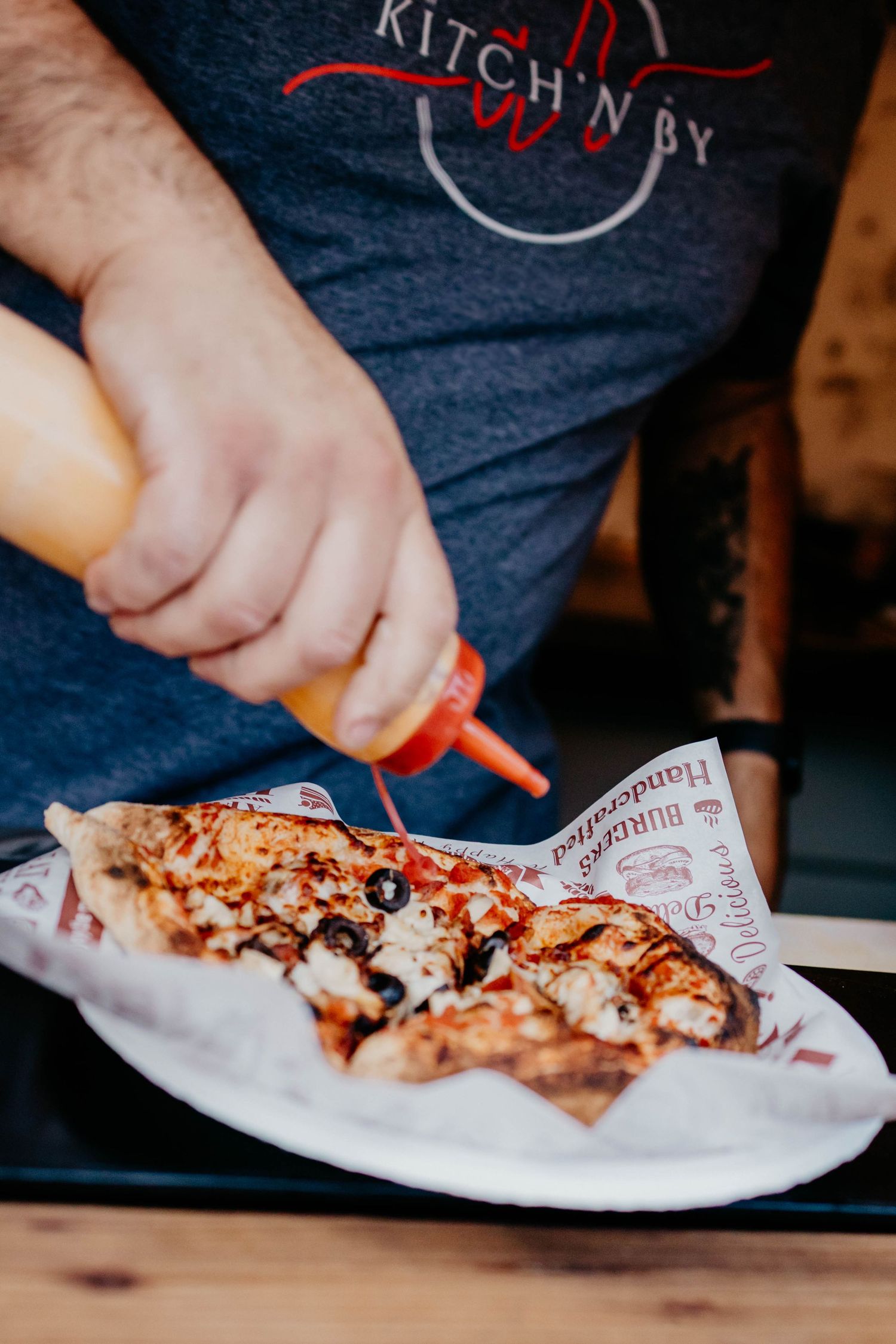 Hands preparing and slicing pizza on white paper in a sequence of progressive shots.