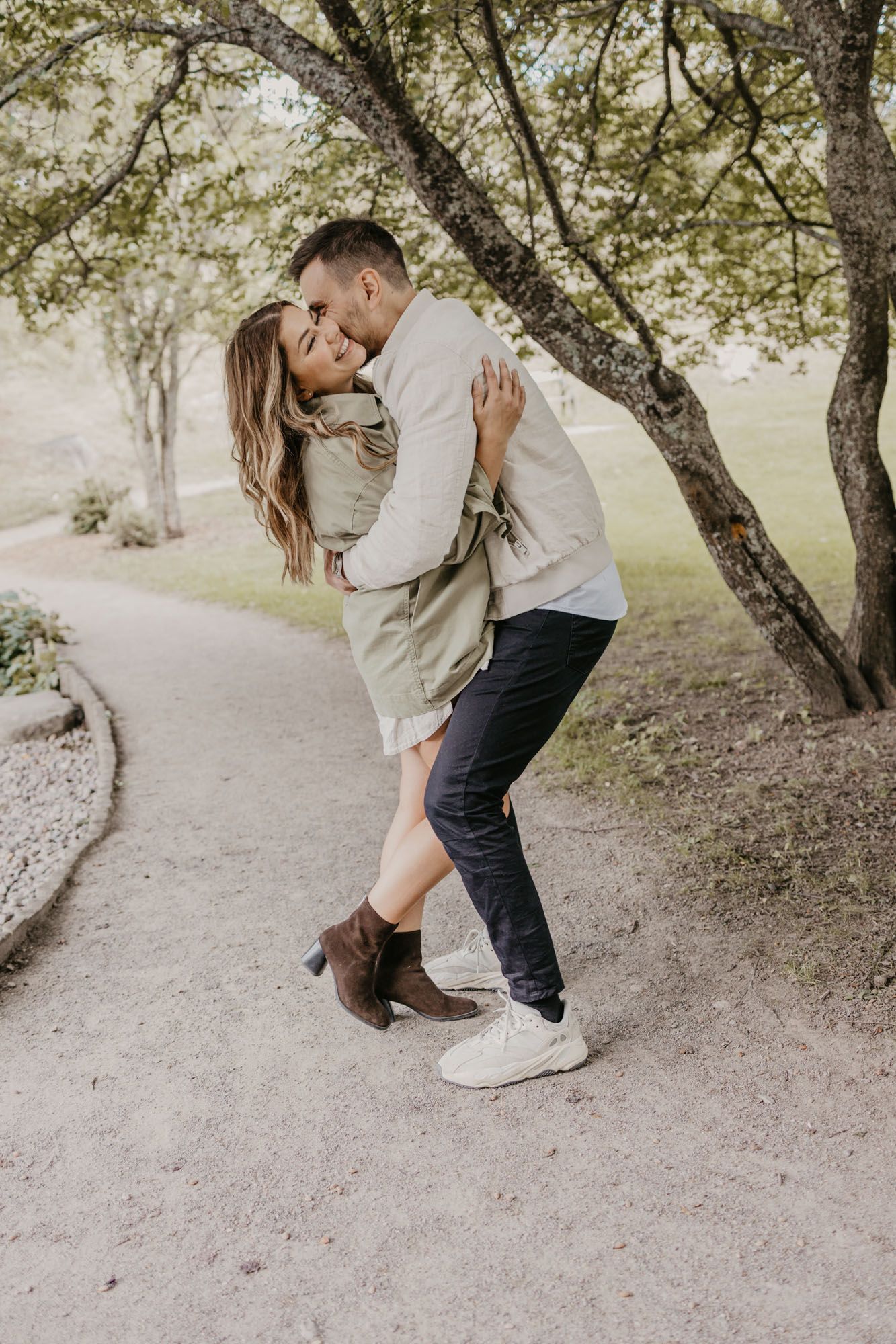 A loving couple dances together on a winding park path.
