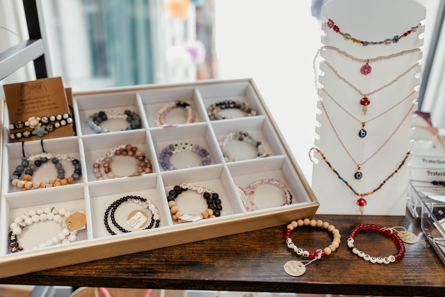 Jewelry display case showing bracelets and necklaces with gemstone and crystal details.