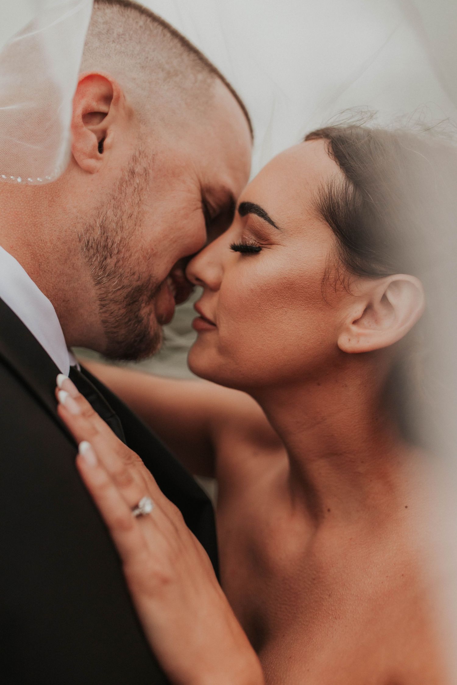 A tender close-up portrait of newlyweds sharing an intimate moment.