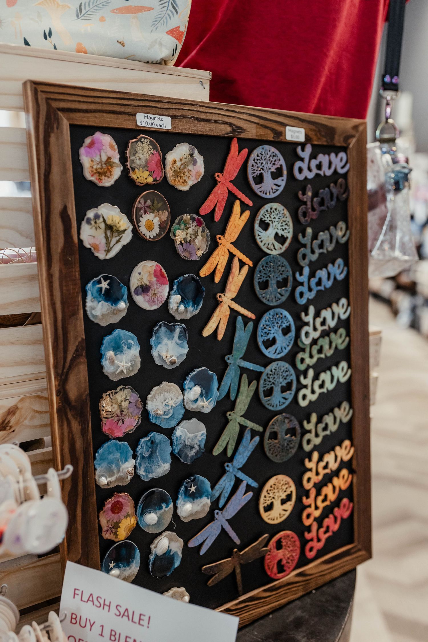 Decorative wooden board featuring colorful circular designs and clothespins arranged in pattern.