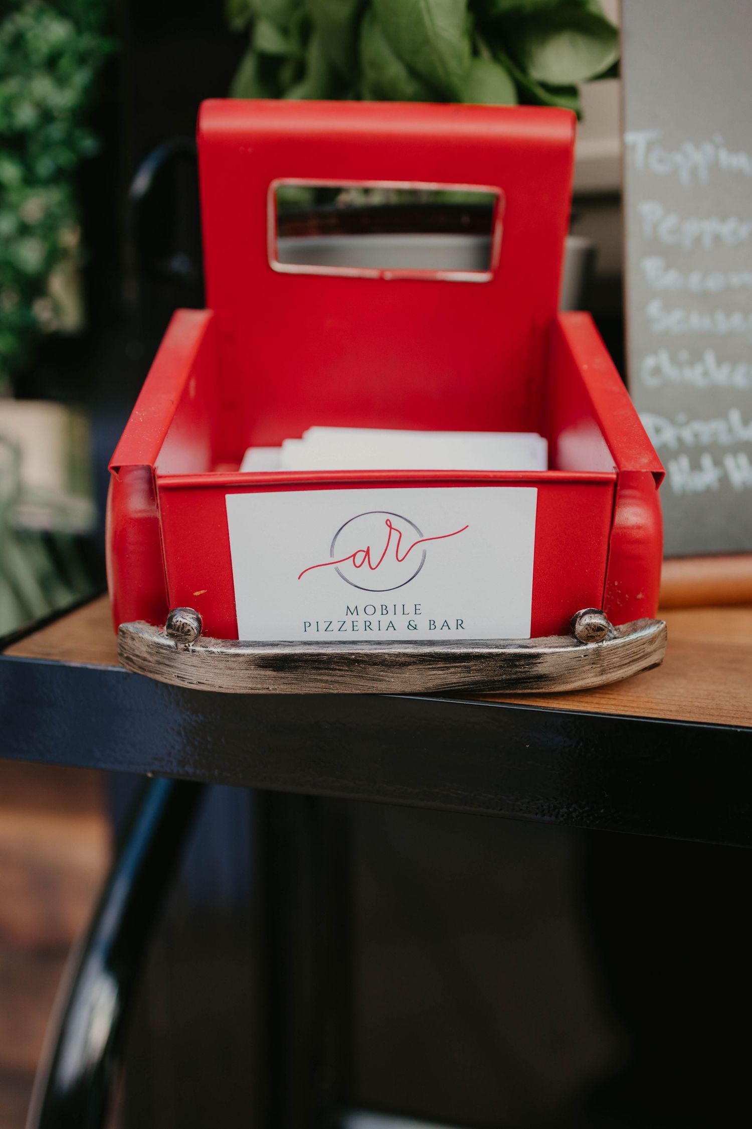 Red pizza delivery boxes stacked on a wooden counter with a restaurant logo visible.