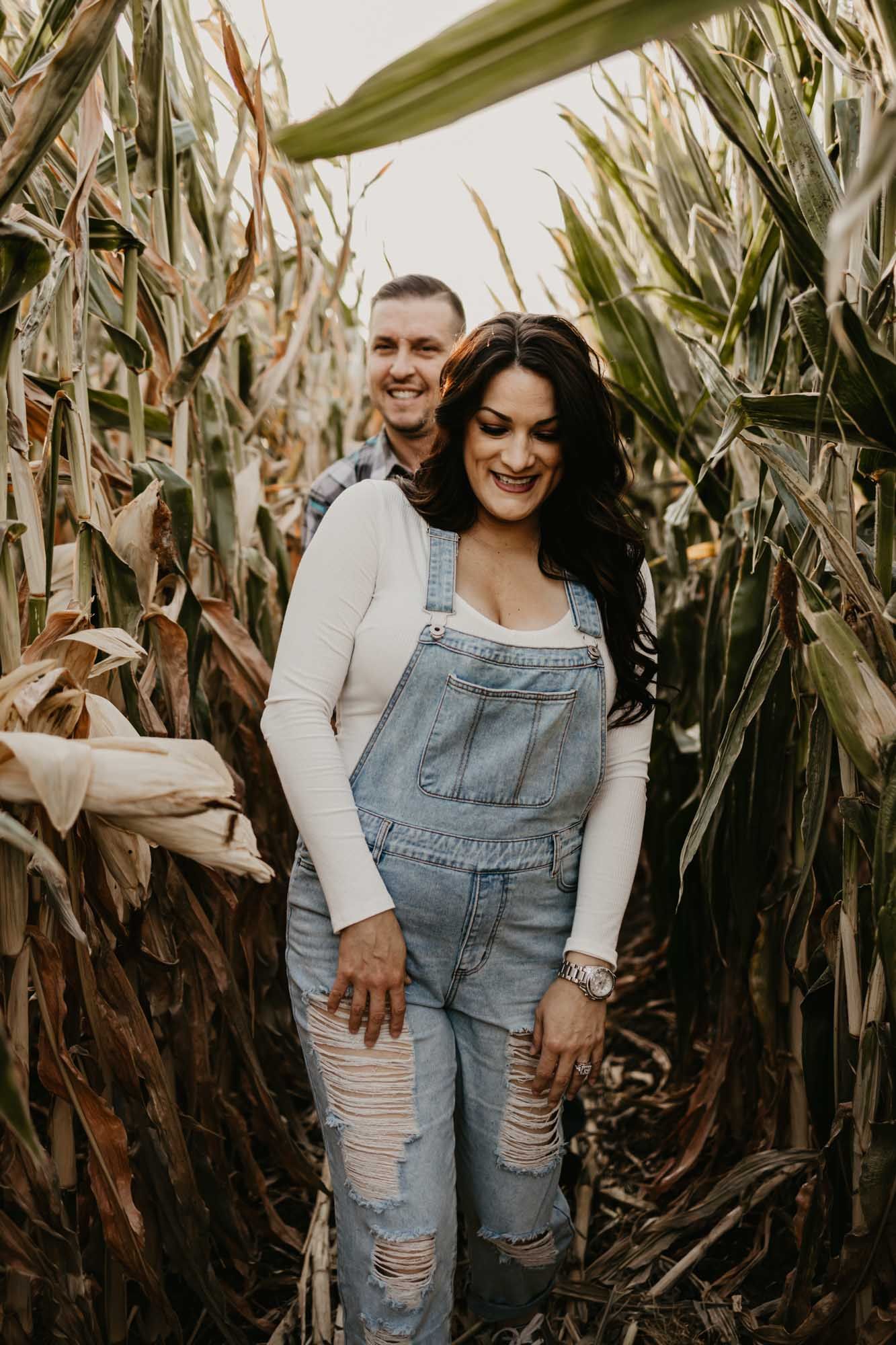 A couple sharing a joyful moment together among tall corn stalks.