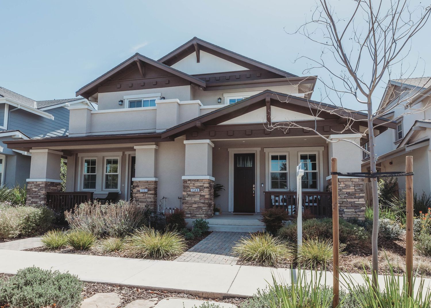 Modern ranch-style homes with desert landscaping under blue sky.
