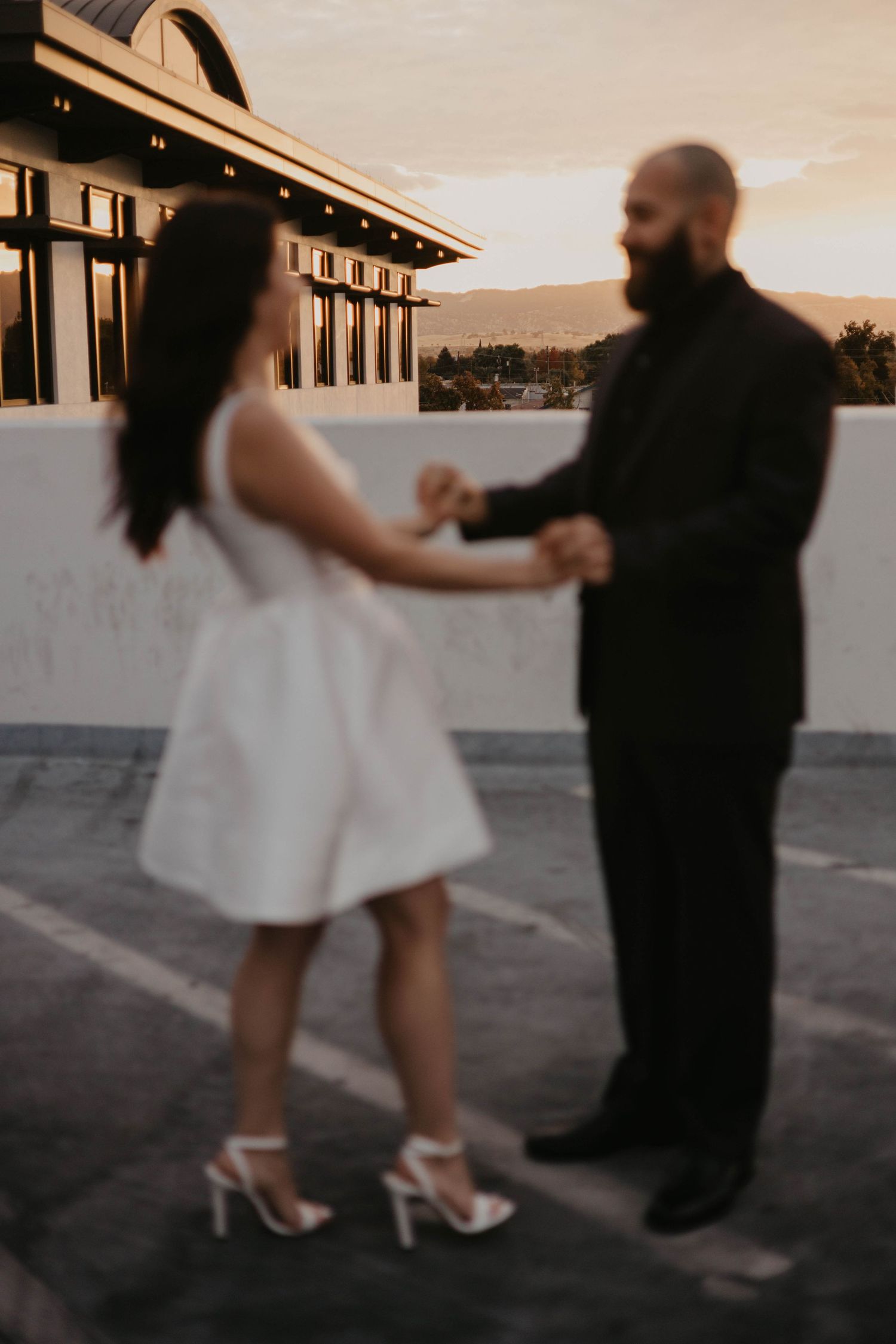 Couple dancing together at sunset on rooftop venue.