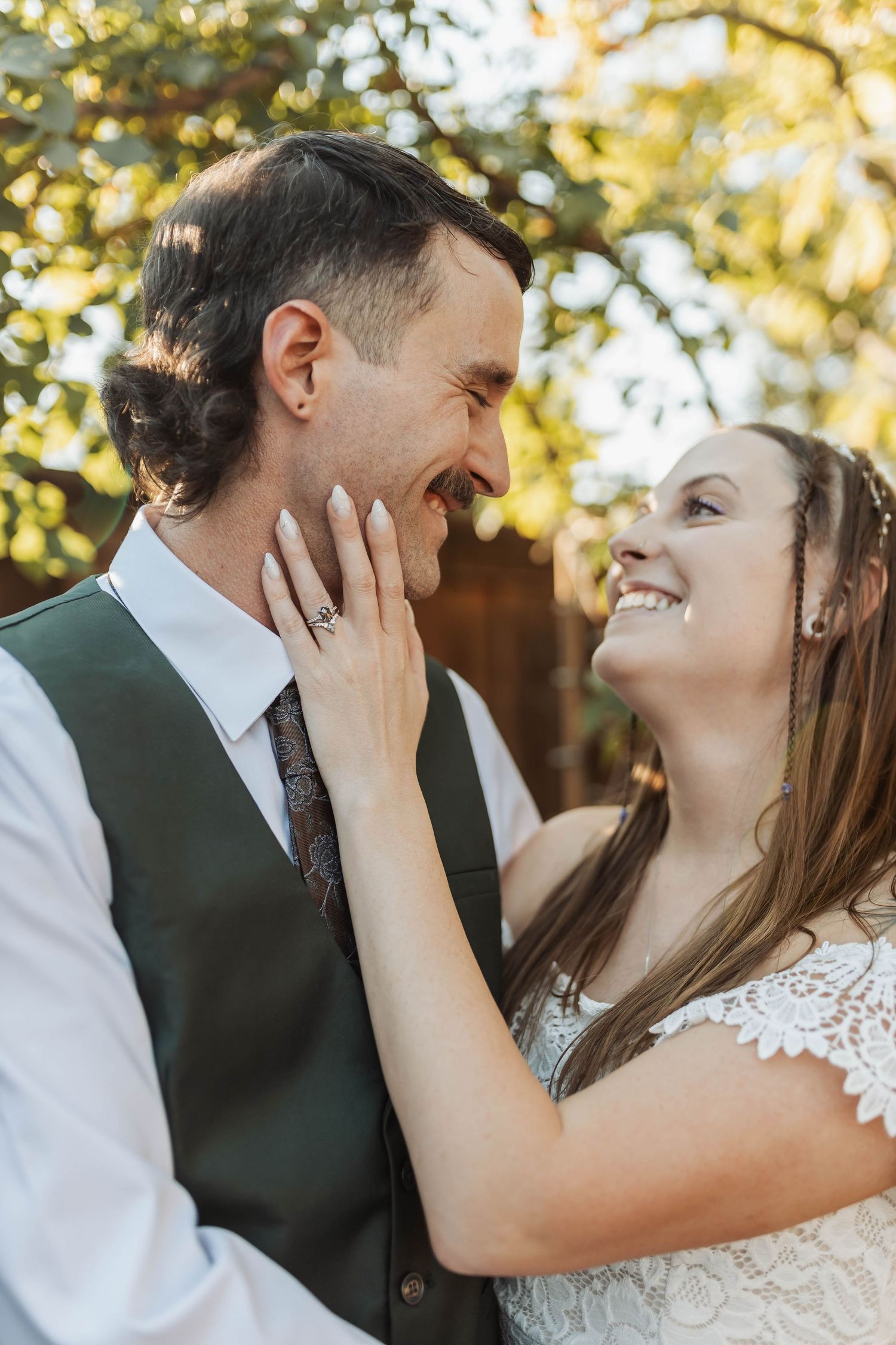 A romantic wedding moment captured in golden sunlight showing a couple sharing an intimate laugh.