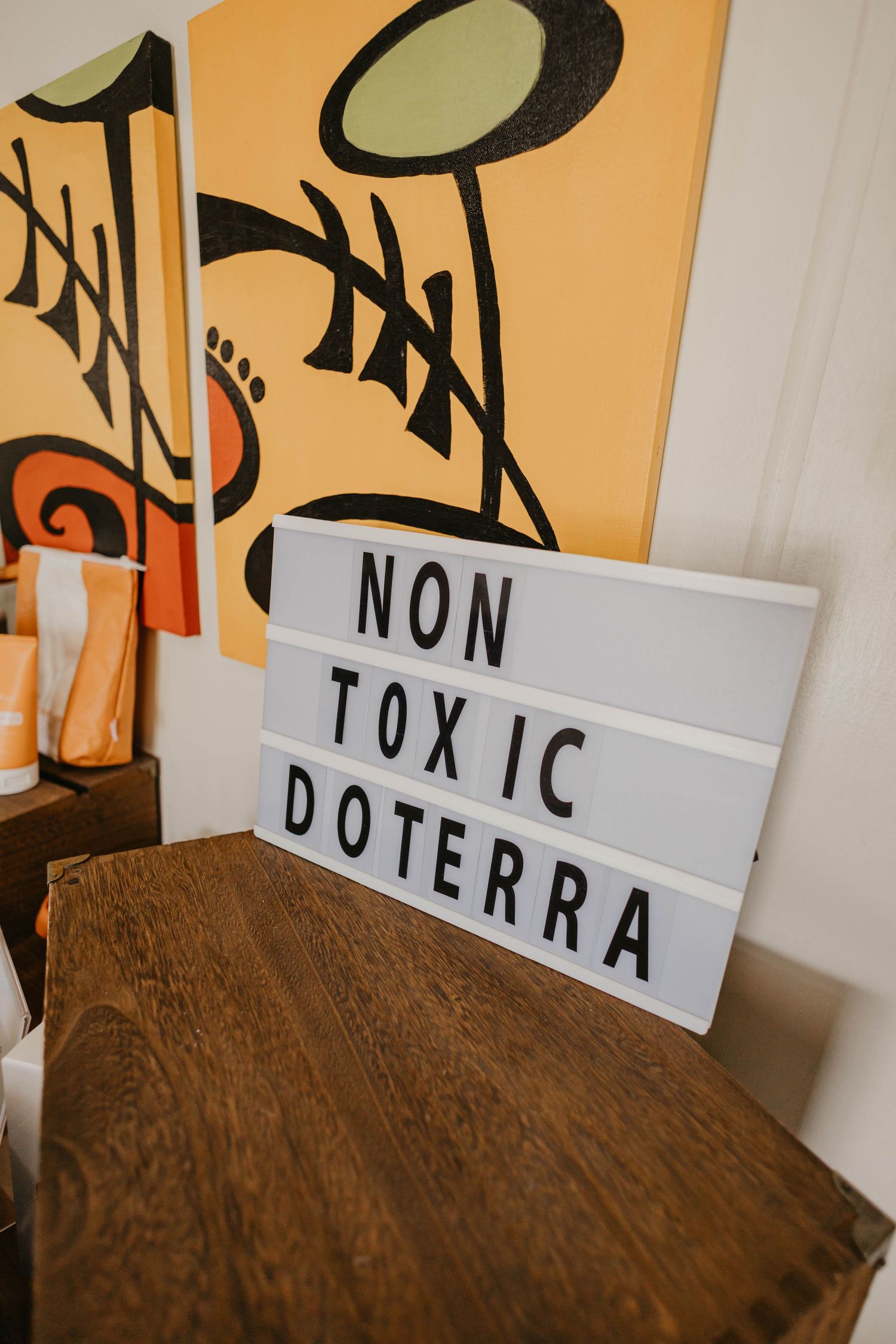 Decorative signs with text 'NON TOXIC DRA' against an orange wall.