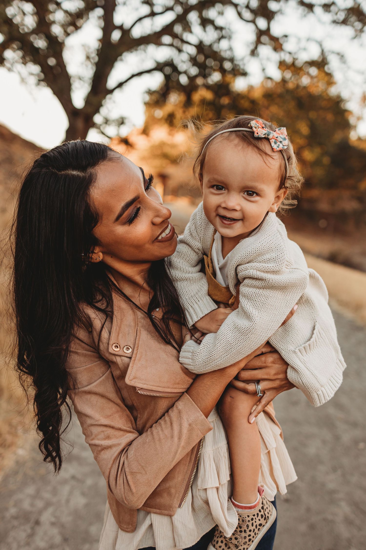 Parent and child sharing joyful moment together outdoors during sunset.