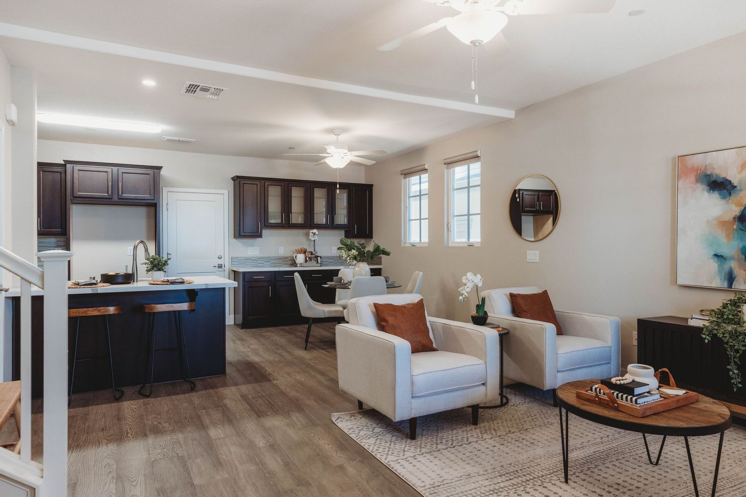 Open concept living space with hardwood floors, white walls, and modern furnishings.