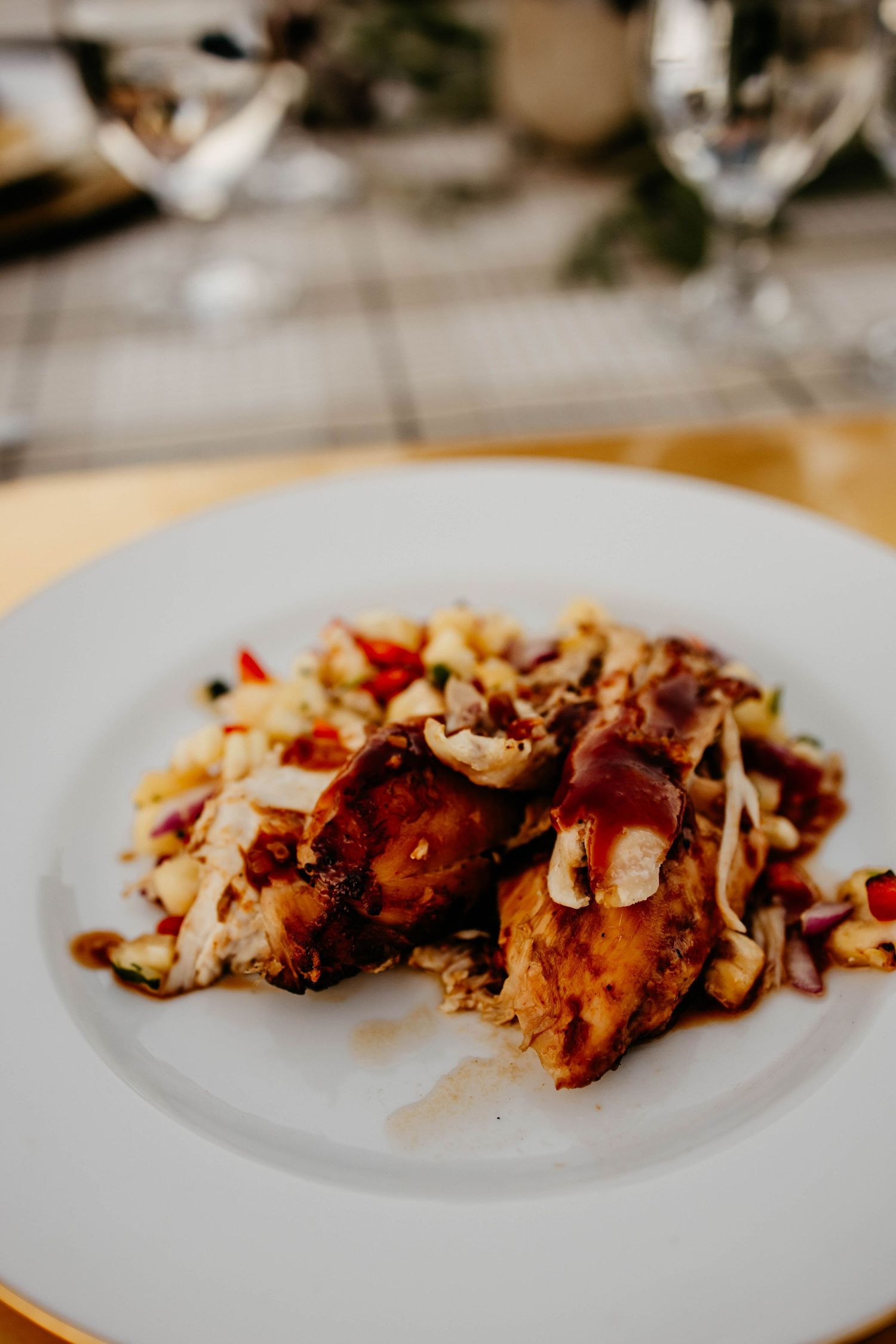 Plated gourmet dish with meat and garnishes served on white dinnerware.