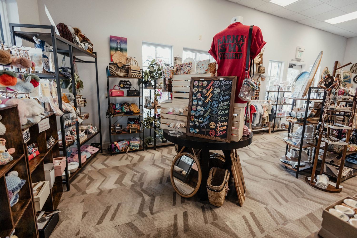 Modern retail space with industrial shelving and chevron patterned carpet displaying clothing and accessories.
