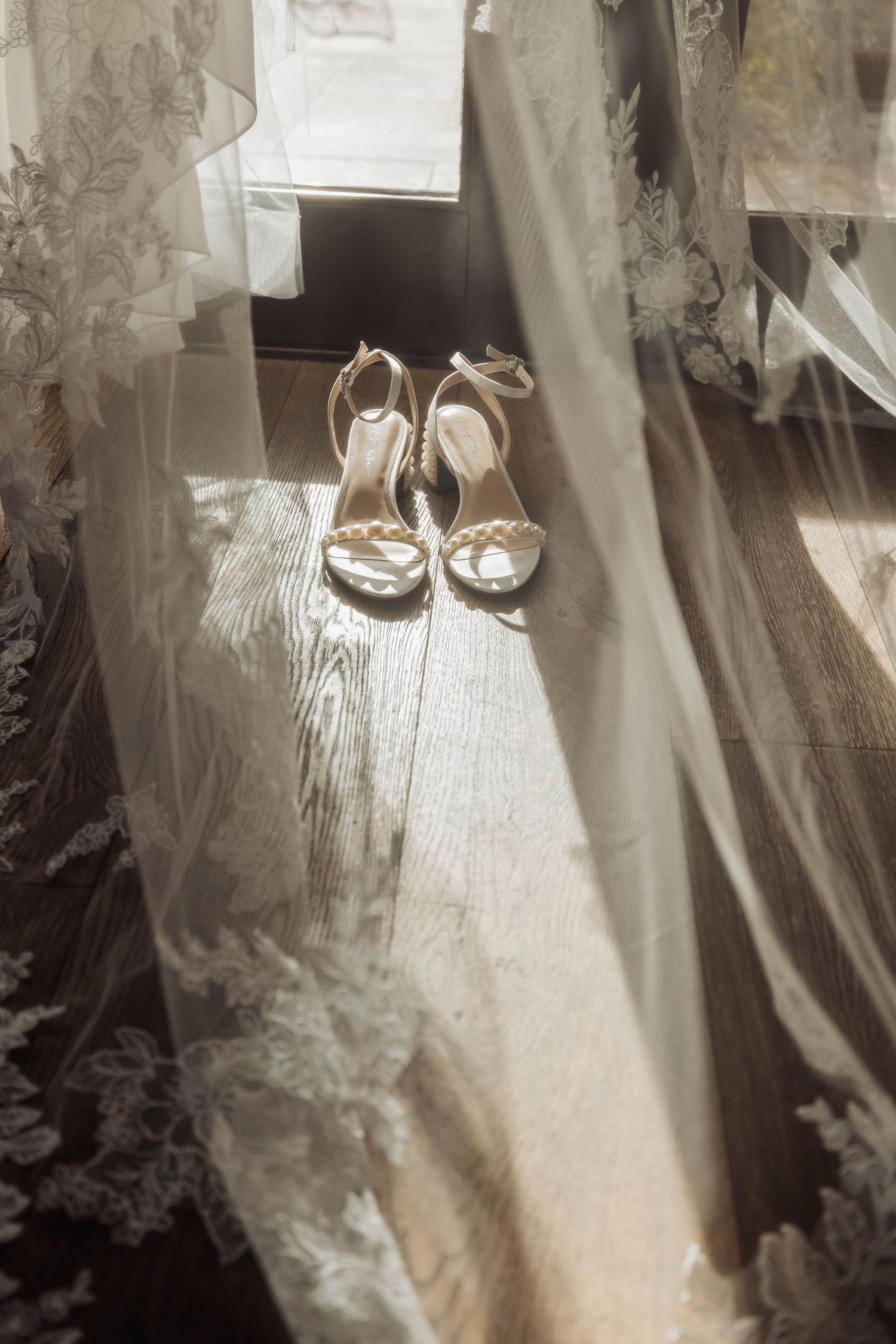 Wedding accessories and veil photographed with dramatic lighting and shadows.