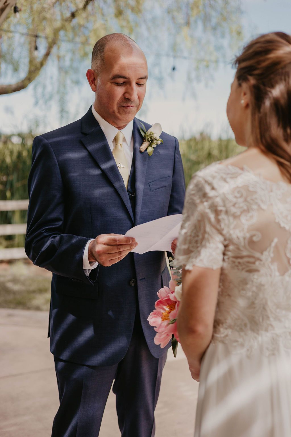An intimate wedding ceremony moment with vows being exchanged on a covered patio.