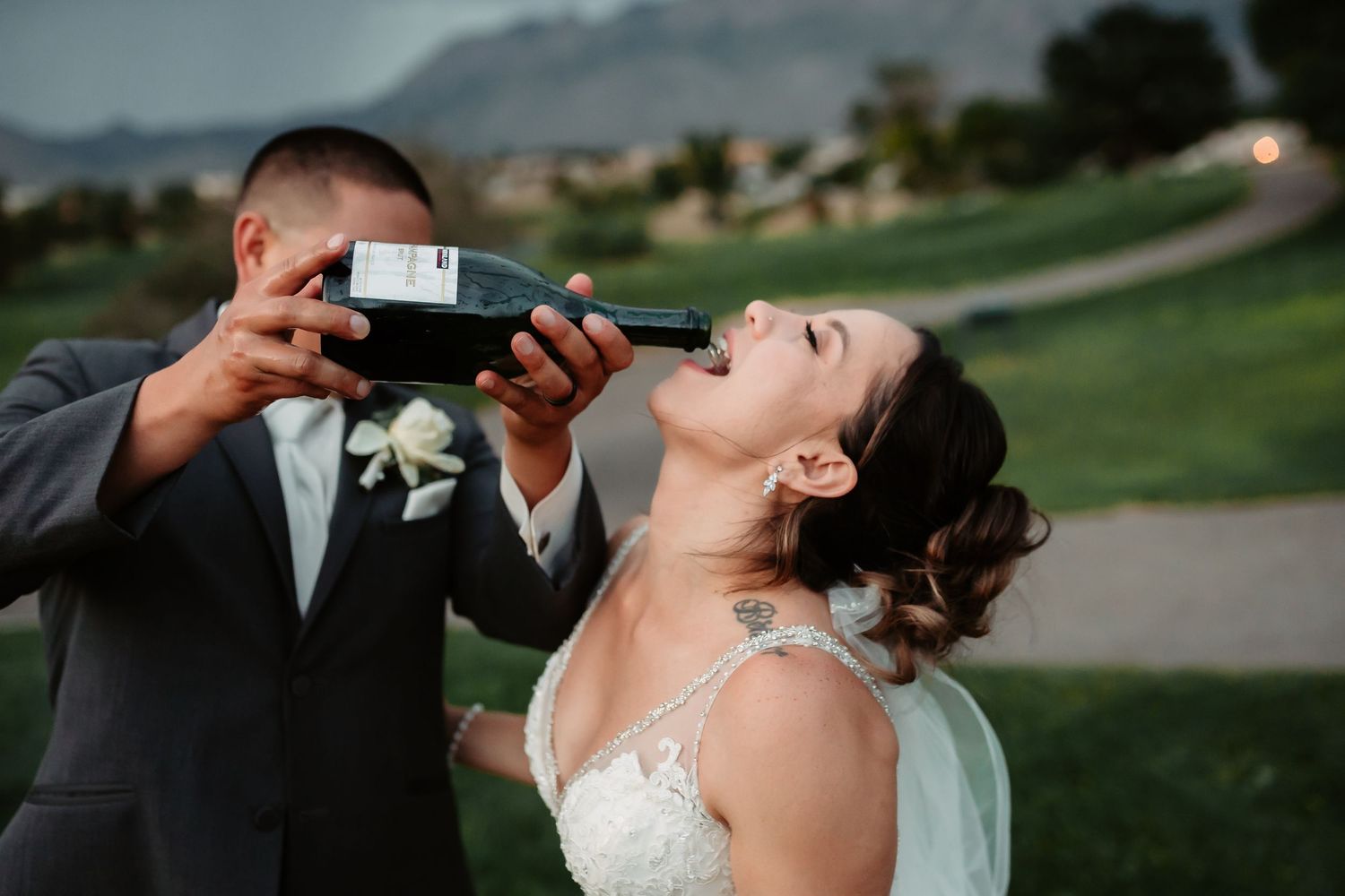 Bridal couple shares playful moments on a golf course during golden hour photography.