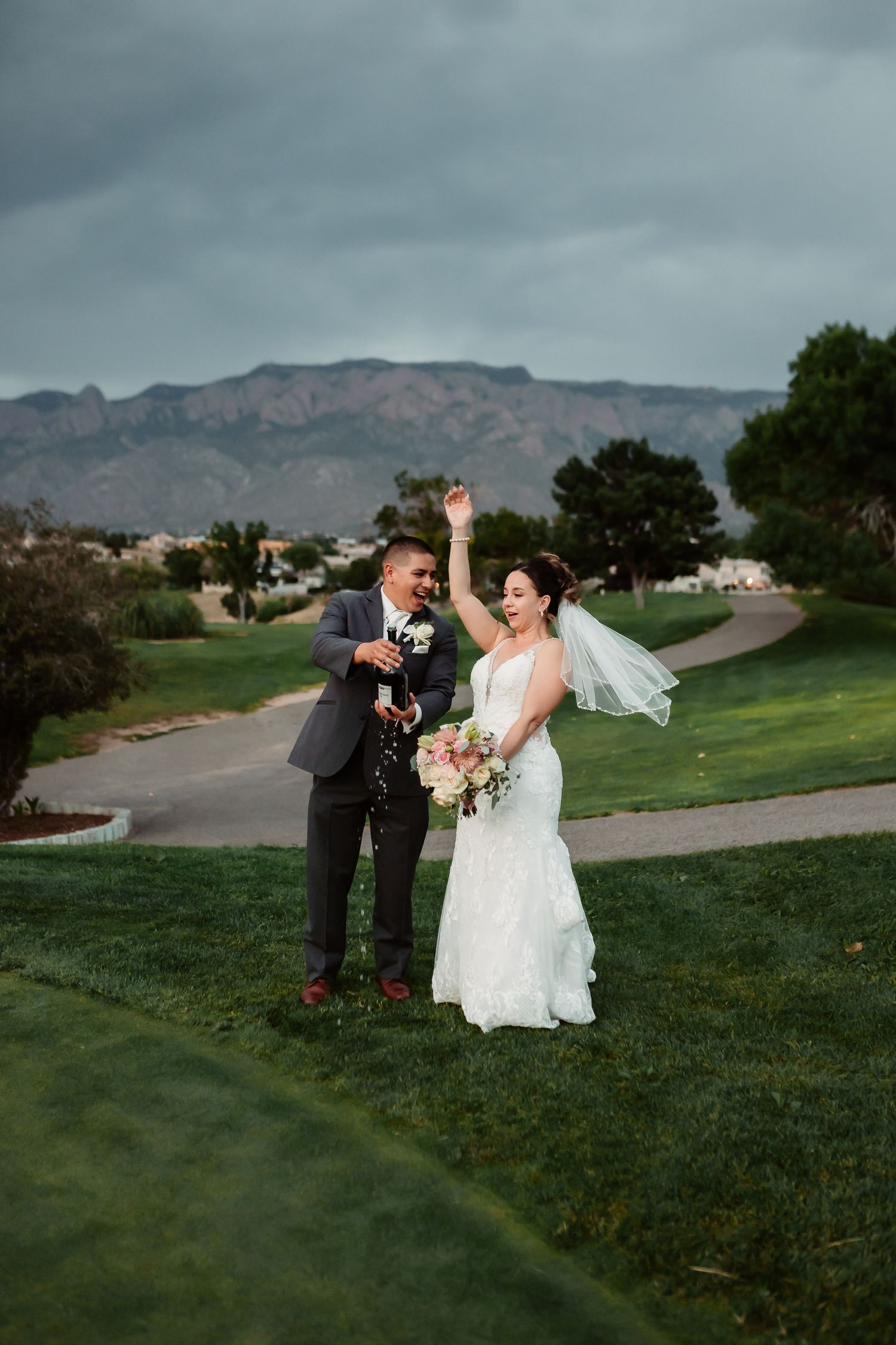 Scenic wedding photography on a grassy hill with mountain views in the background.