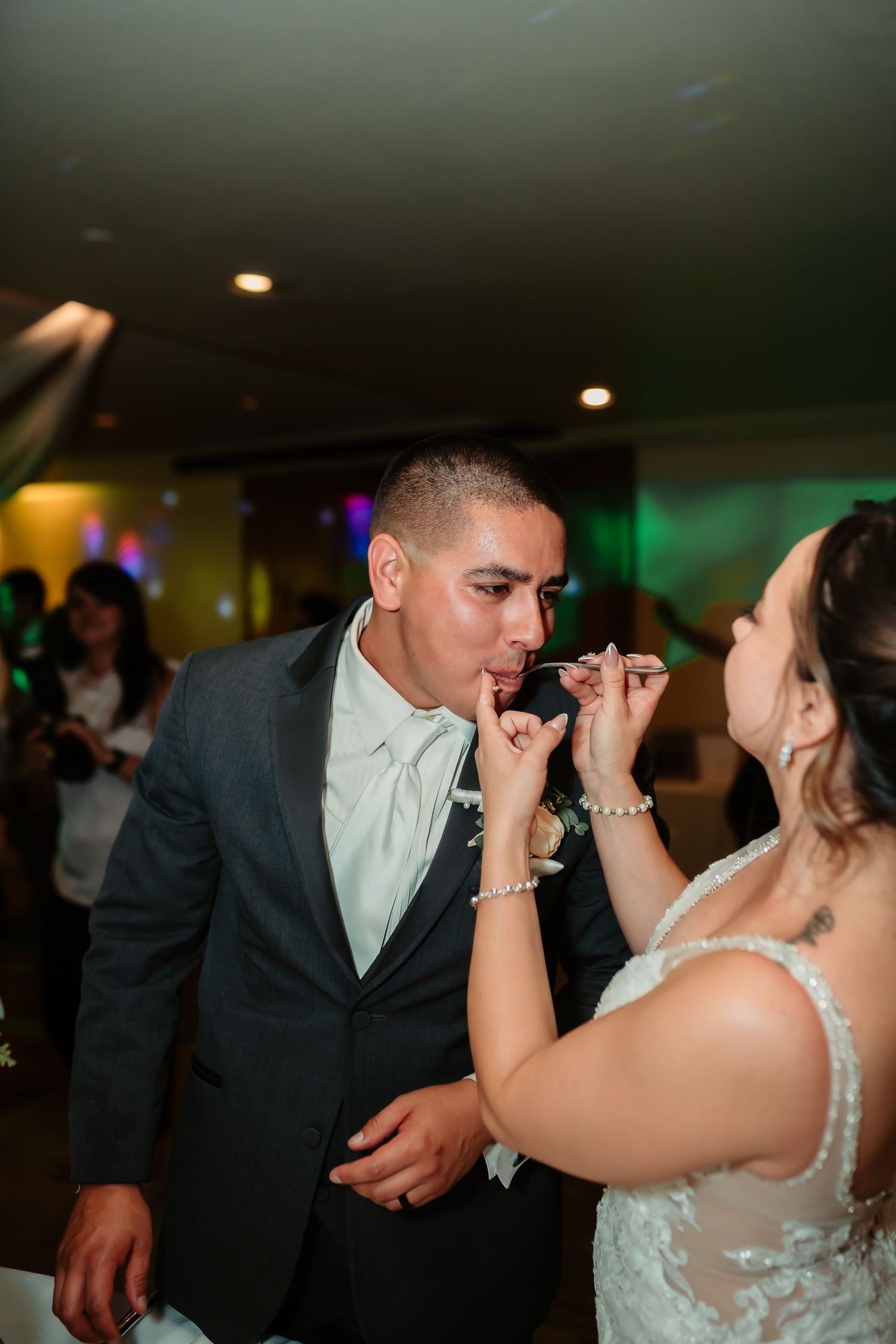 Couple sharing an intimate moment while dancing at their wedding reception under dimmed lighting.