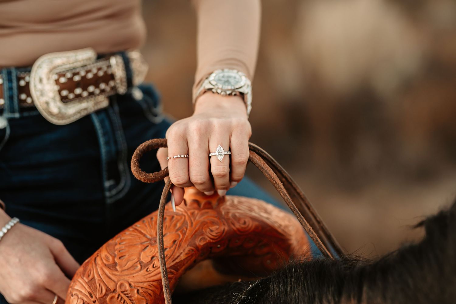 Hands working on detailed leather tooling and craftsmanship showing intricate patterns and designs.