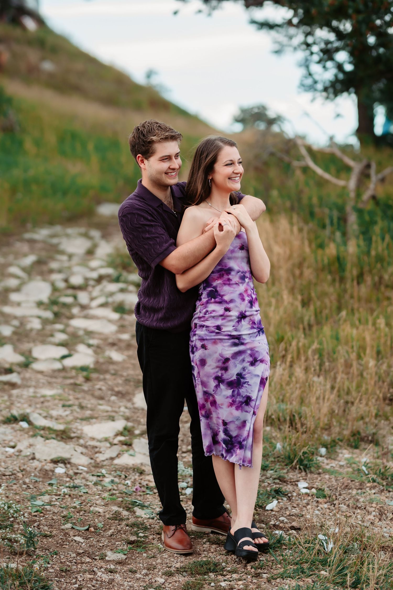 A playful engagement photography session on a rocky mountain path.